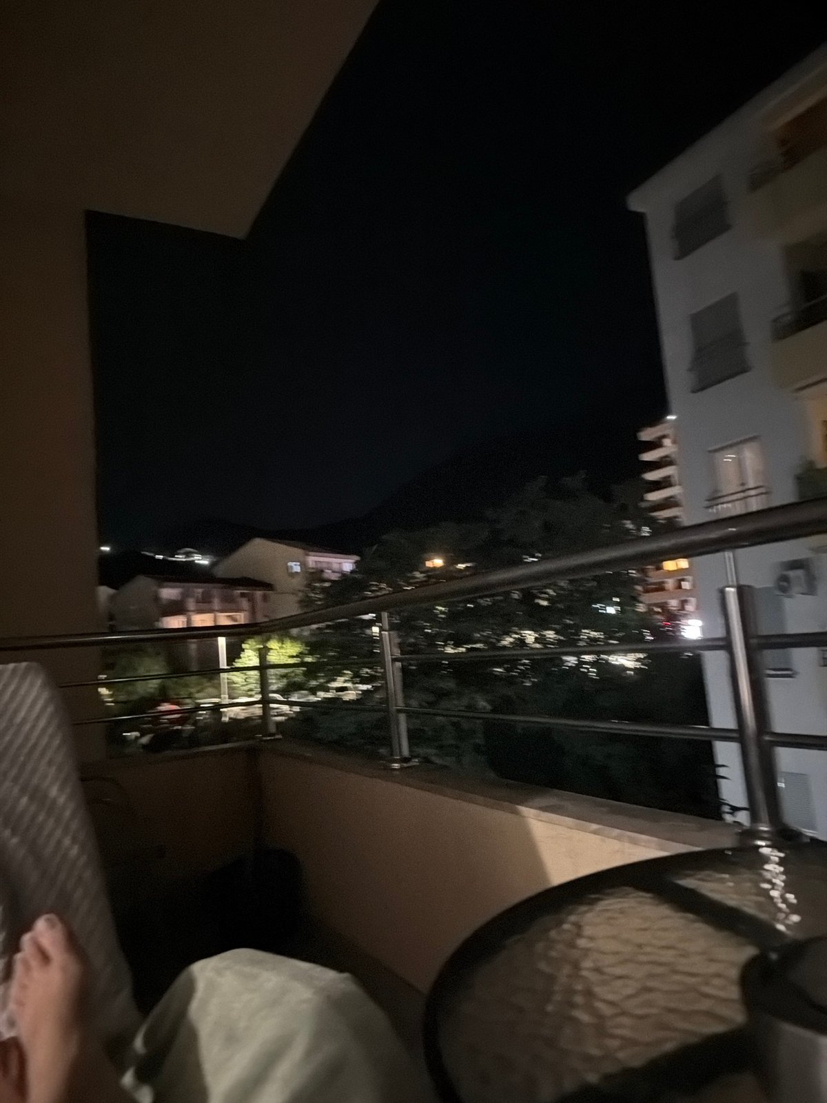 Evening balcony relaxation overlooking nighttime Budva residential streets