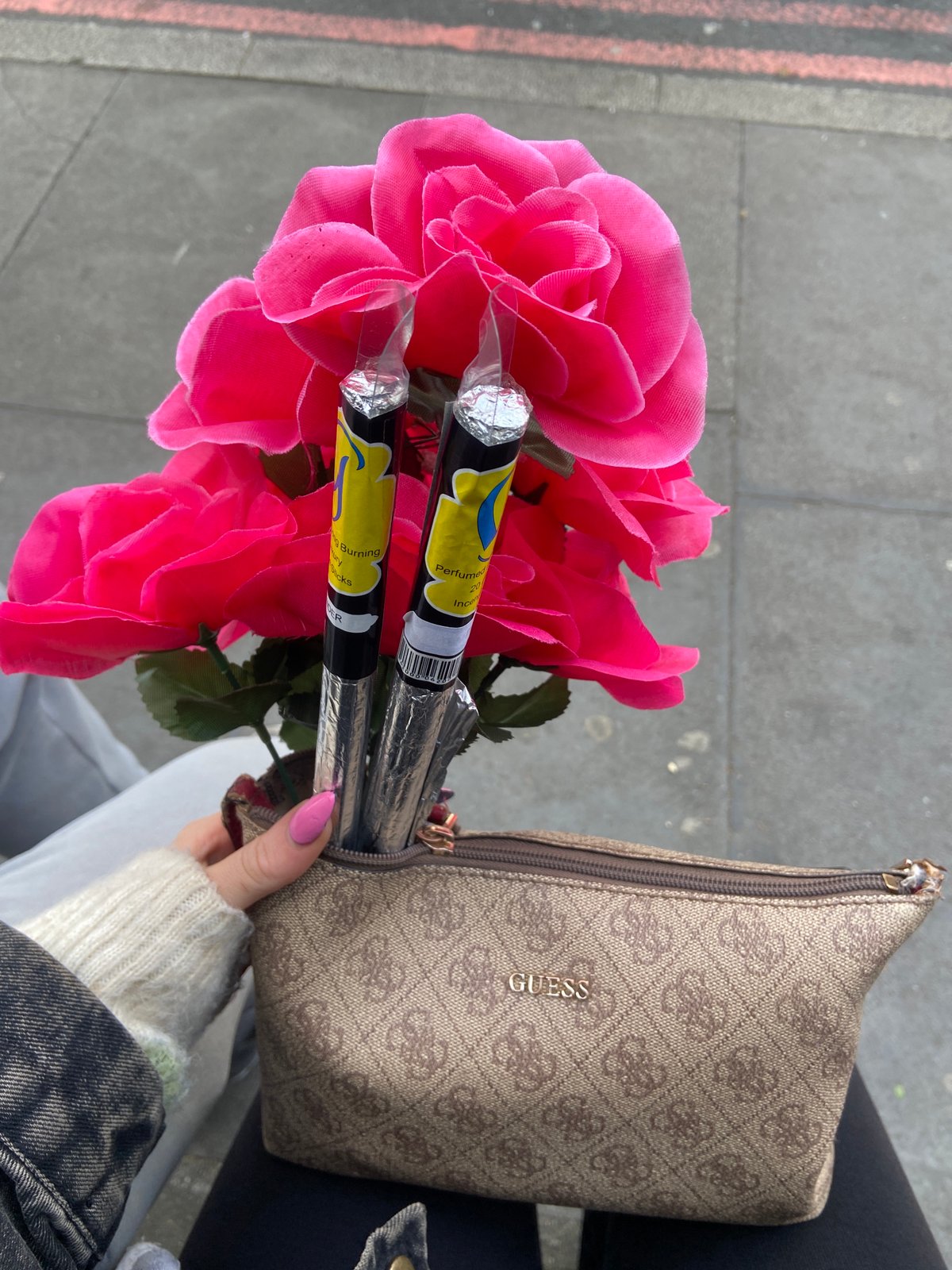 Person holds artificial roses and incense in London