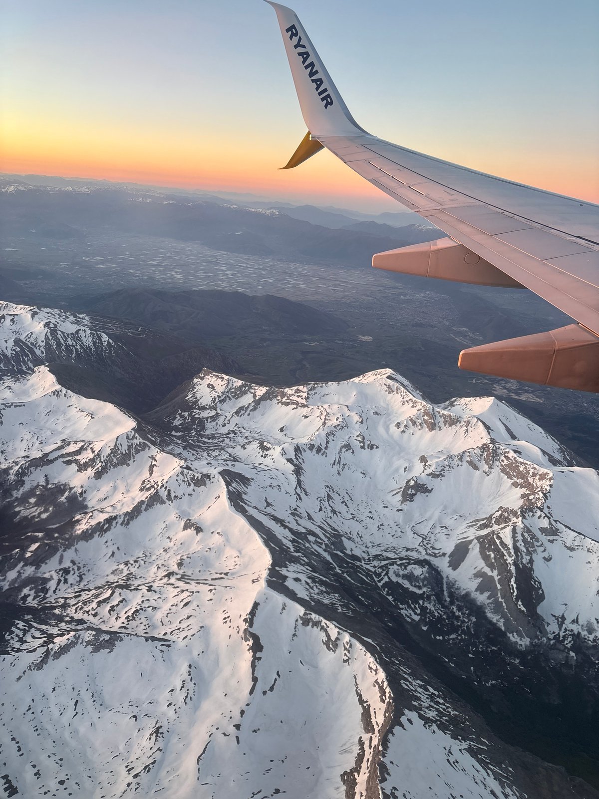 Aerial photo captured from airplane over Rome showing wing, mountains