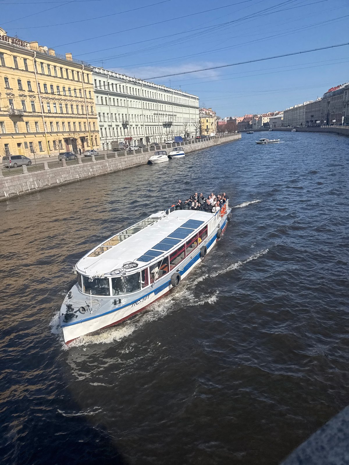 Tourist boats navigate Saint Petersburg canals on sunny morning