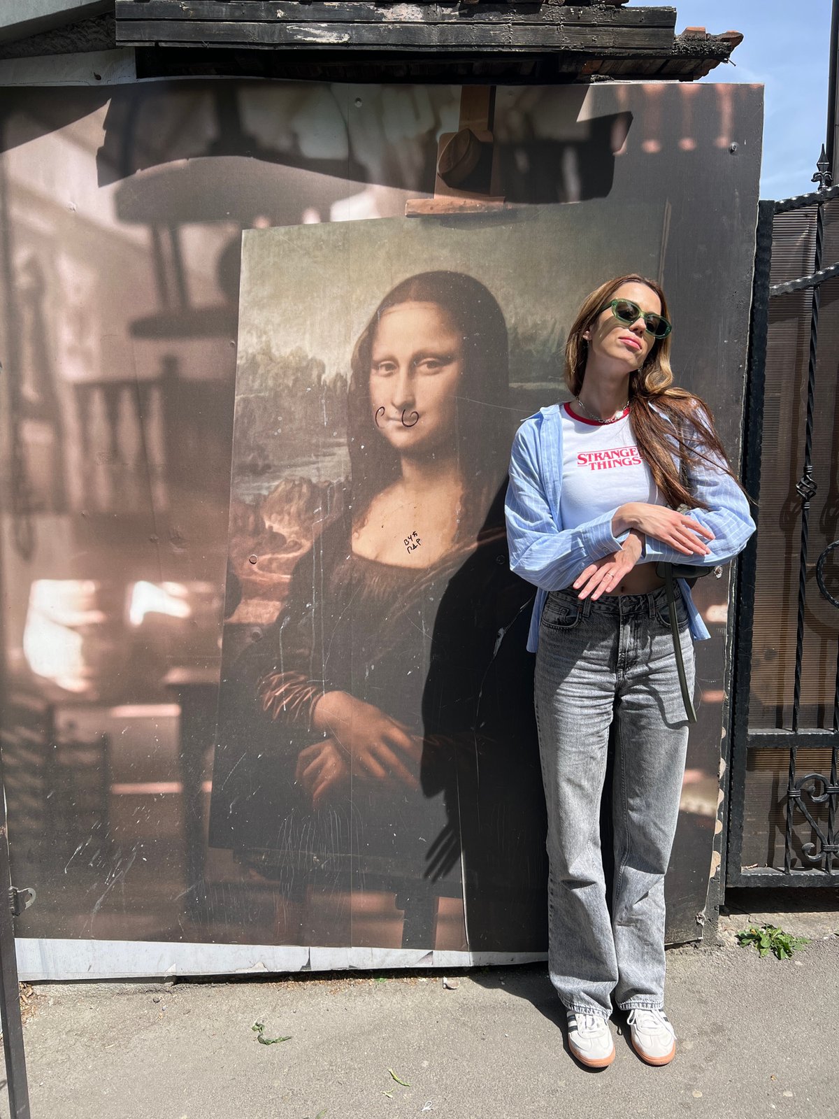 Woman lies on damaged Mona Lisa advertisement in Belgrade suburb
