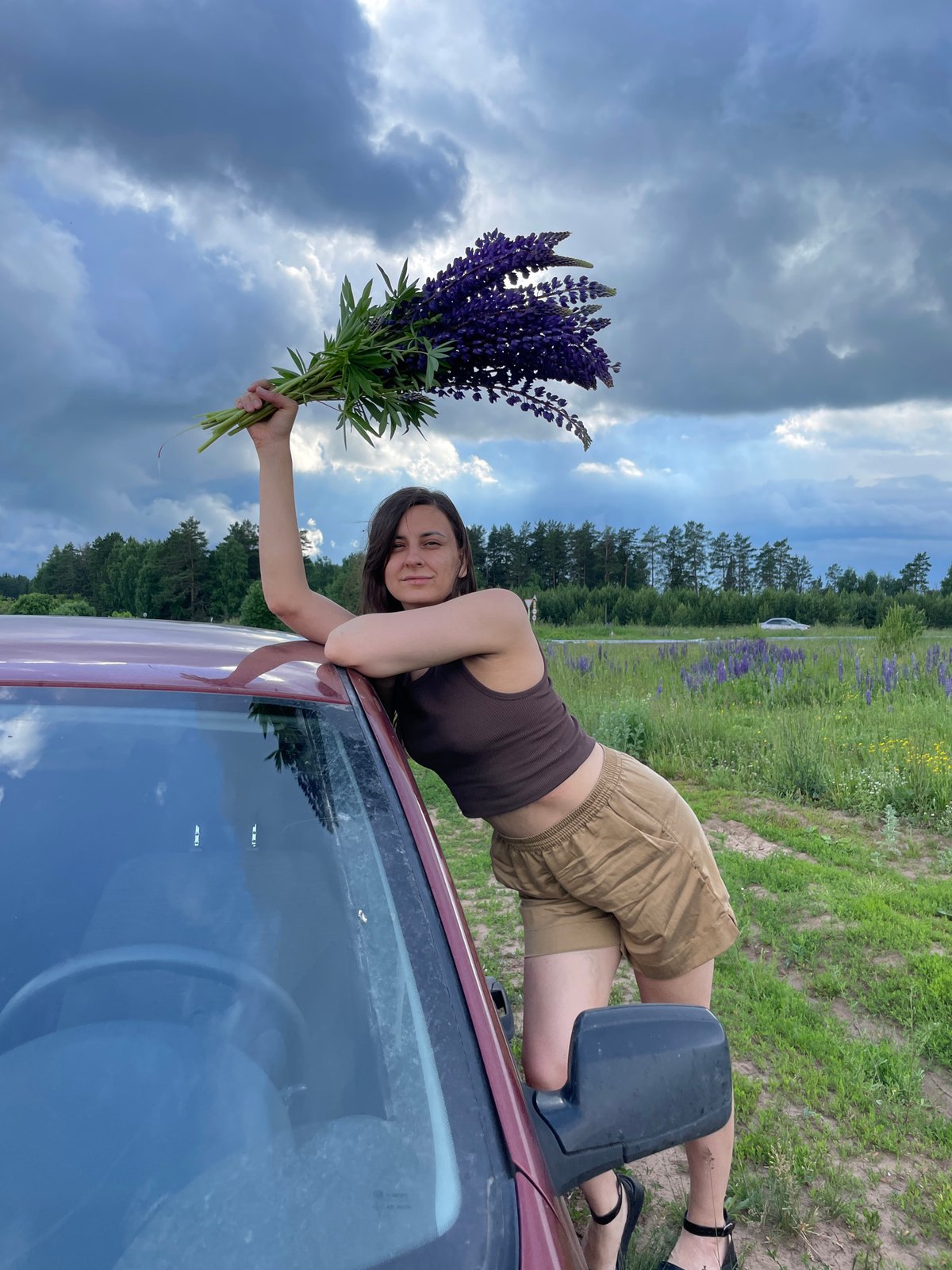 Woman enjoys photo session in Russian lupine flower field