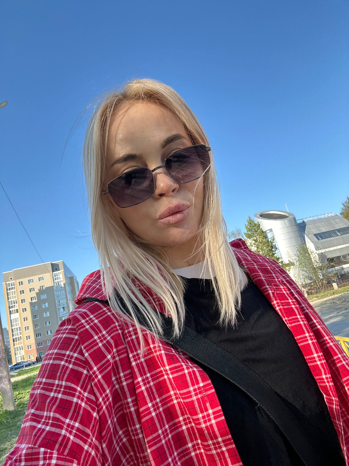 Woman takes selfies around Megion apartment buildings during casual outing