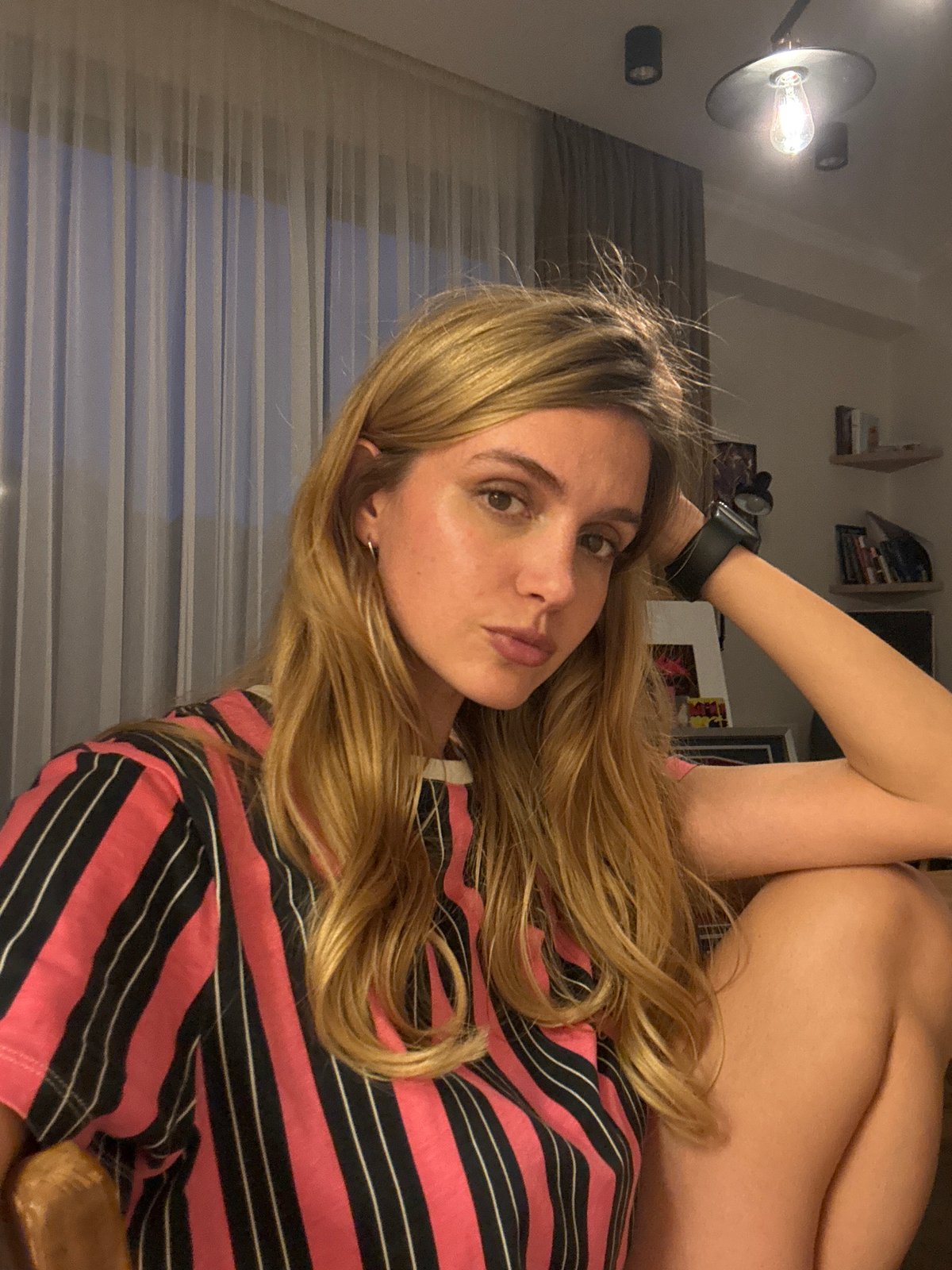 Woman takes indoor selfies in pink striped top