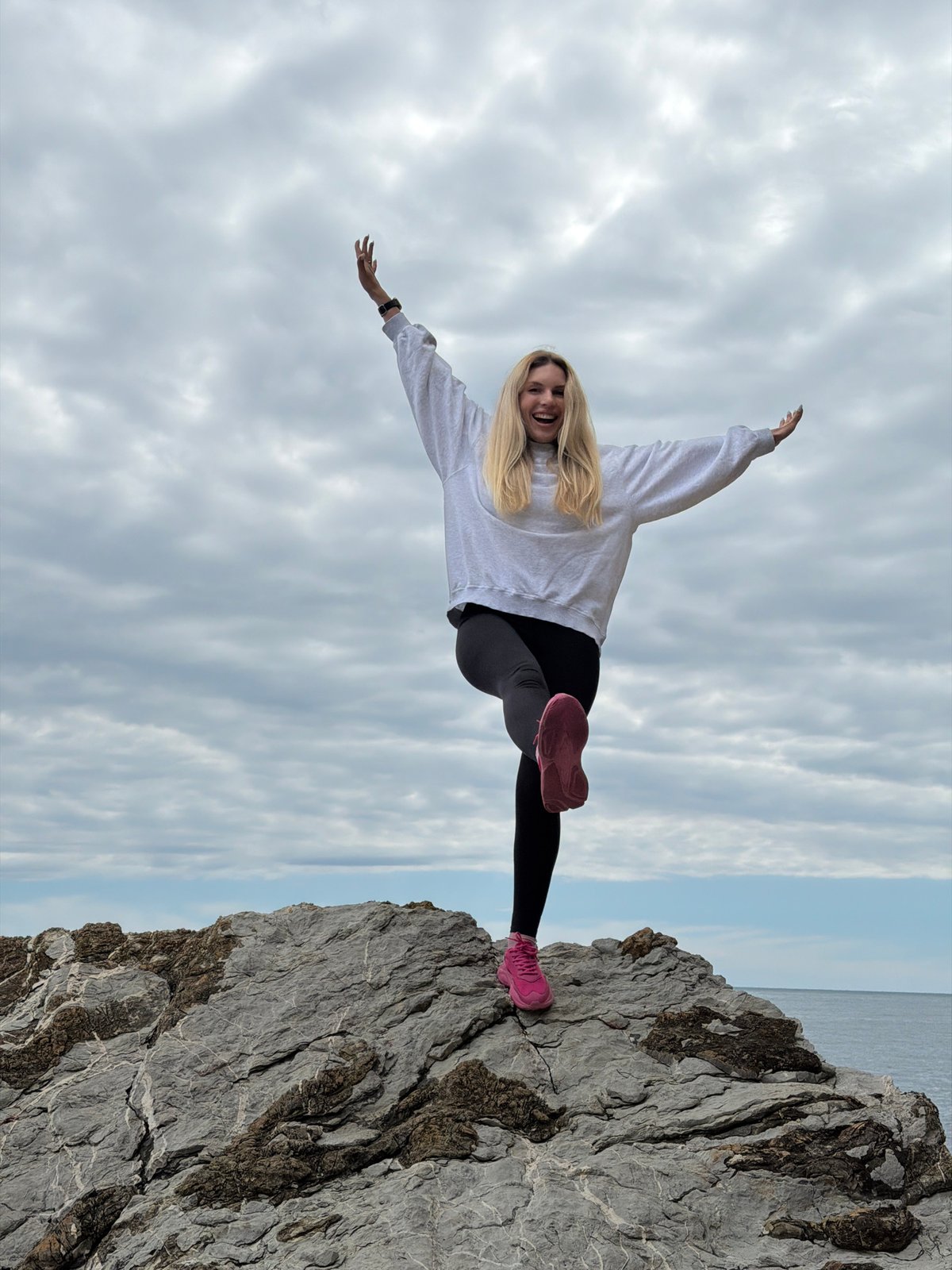 Woman poses on Budva cliffs during Adriatic coastal visit