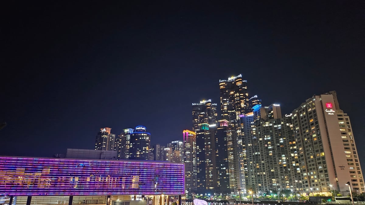 Nighttime scenes captured across Busan include lights, pedestrians, beach performance