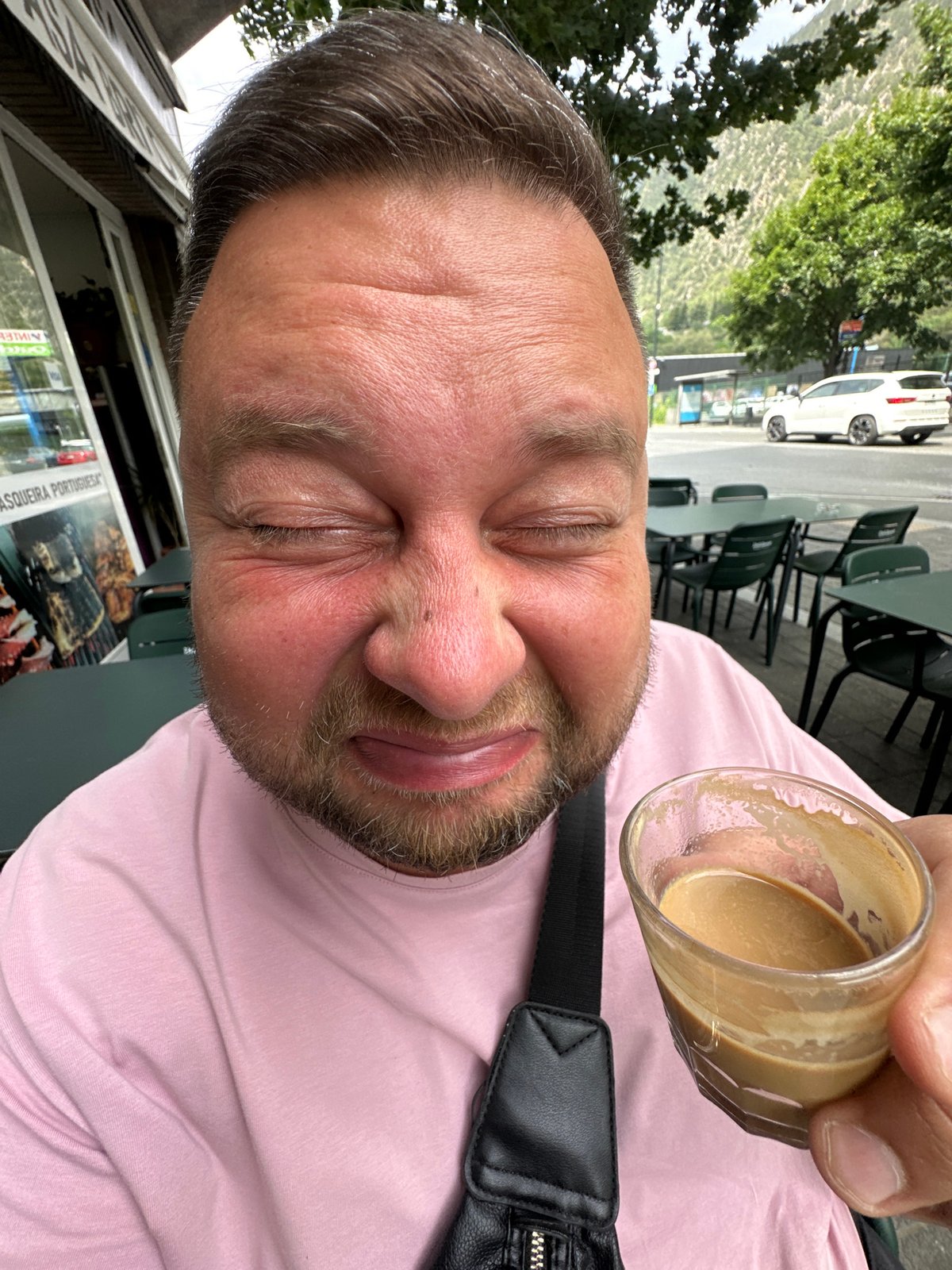 Man enjoys coffee at Andorra cafe, moth spotted nearby