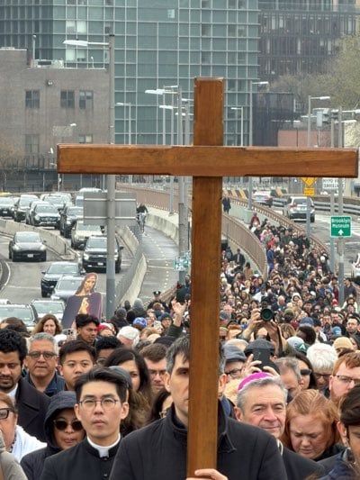 Religious procession with crosses crosses Brooklyn Bridge amid fog