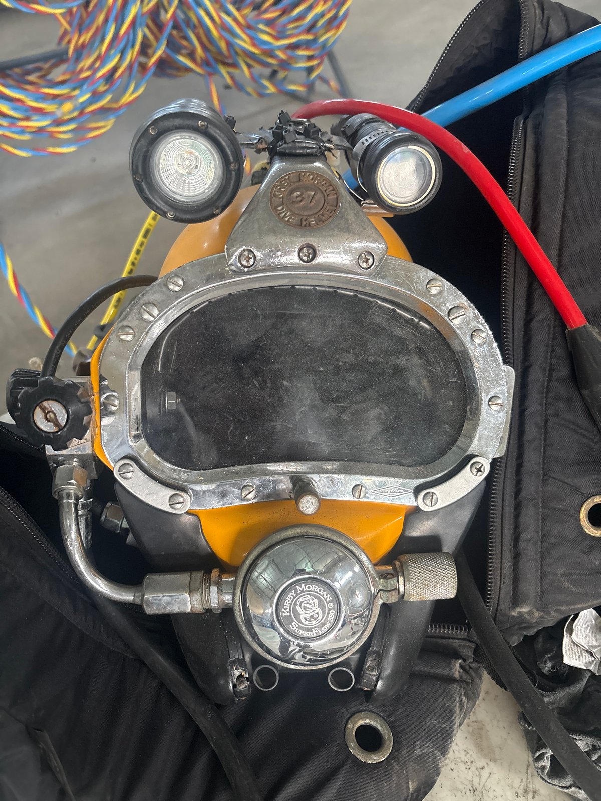 Vintage Kirby Morgan dive helmet resting on a duffel bag, Baku