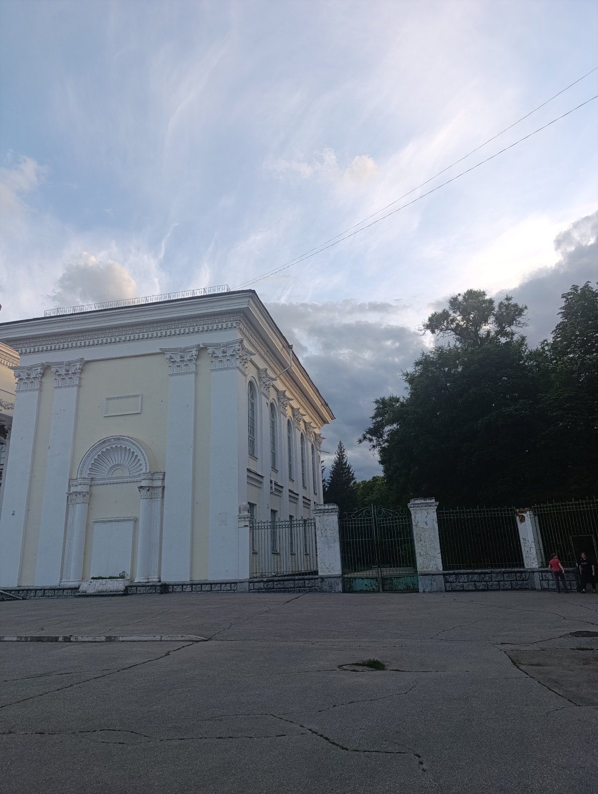 Afternoon park life around classical building with monuments