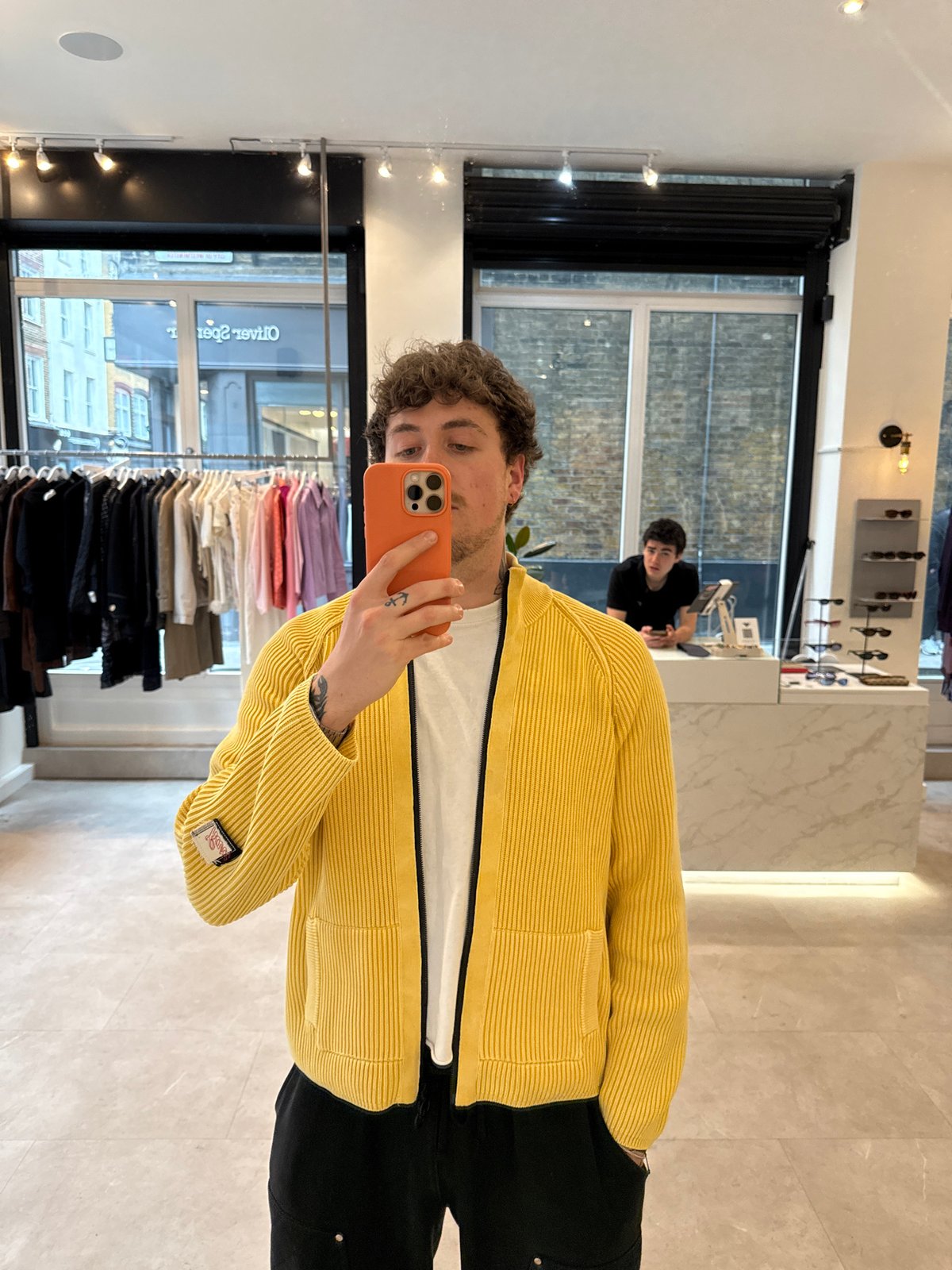 Young man takes mirror selfies in London clothing store