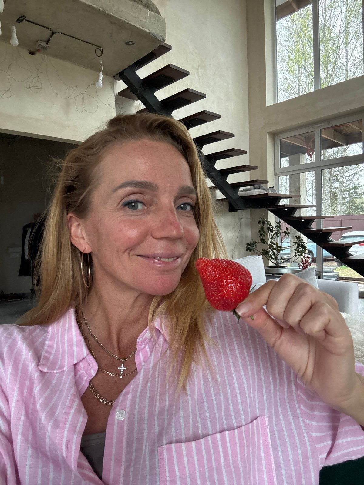 Woman with strawberry, Siamese cat captured in Russian home