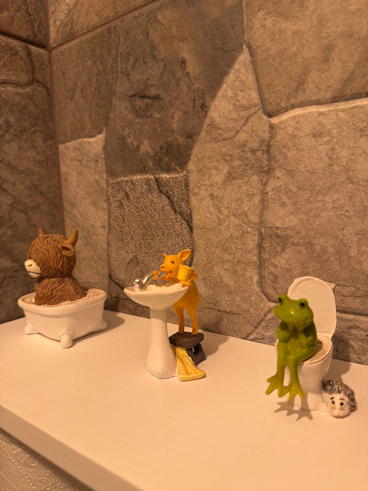 Animal figurines displayed on miniature bathroom fixtures in Cuernavaca