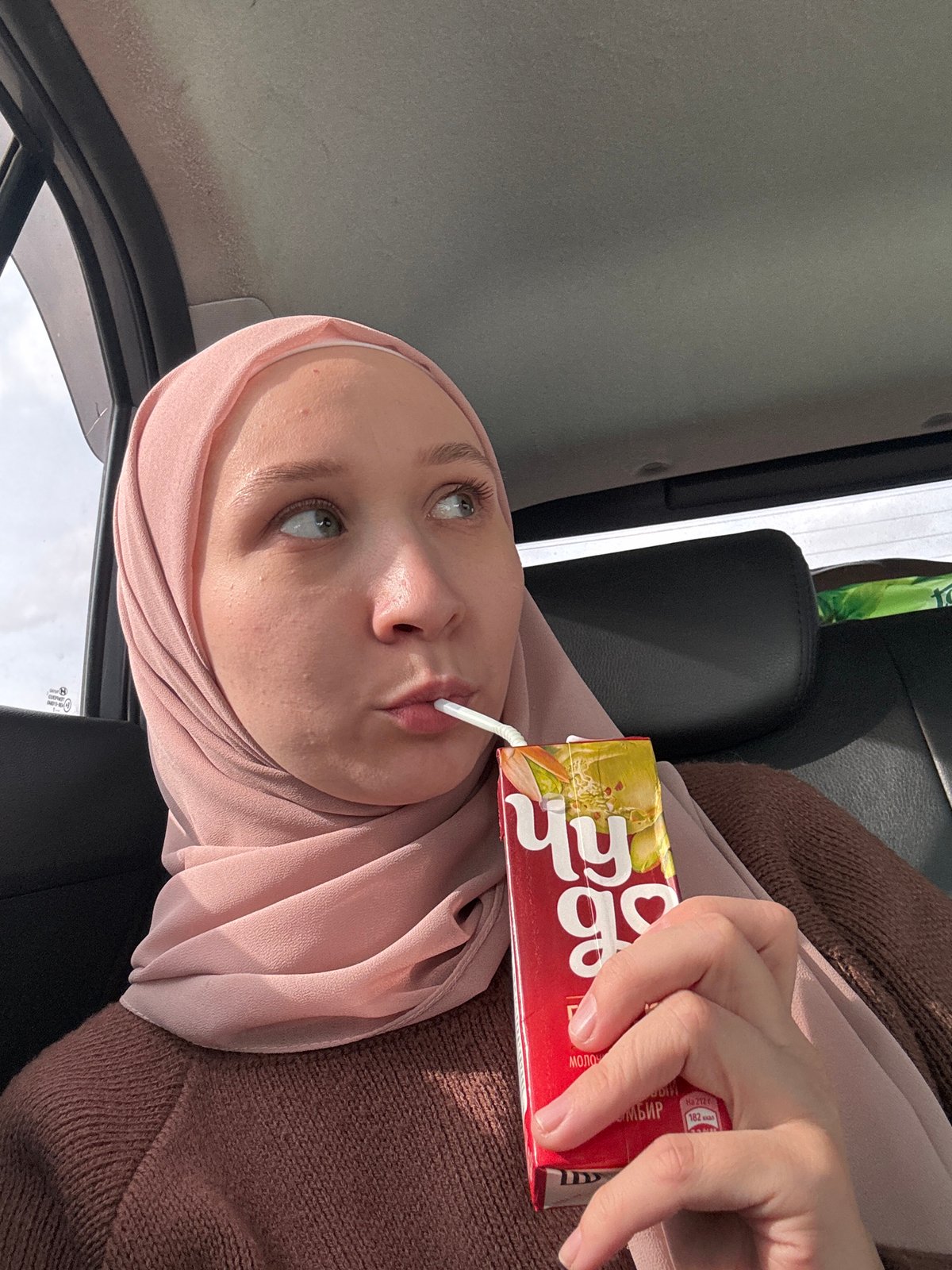 Woman drinks juice in car, Izhevsk
