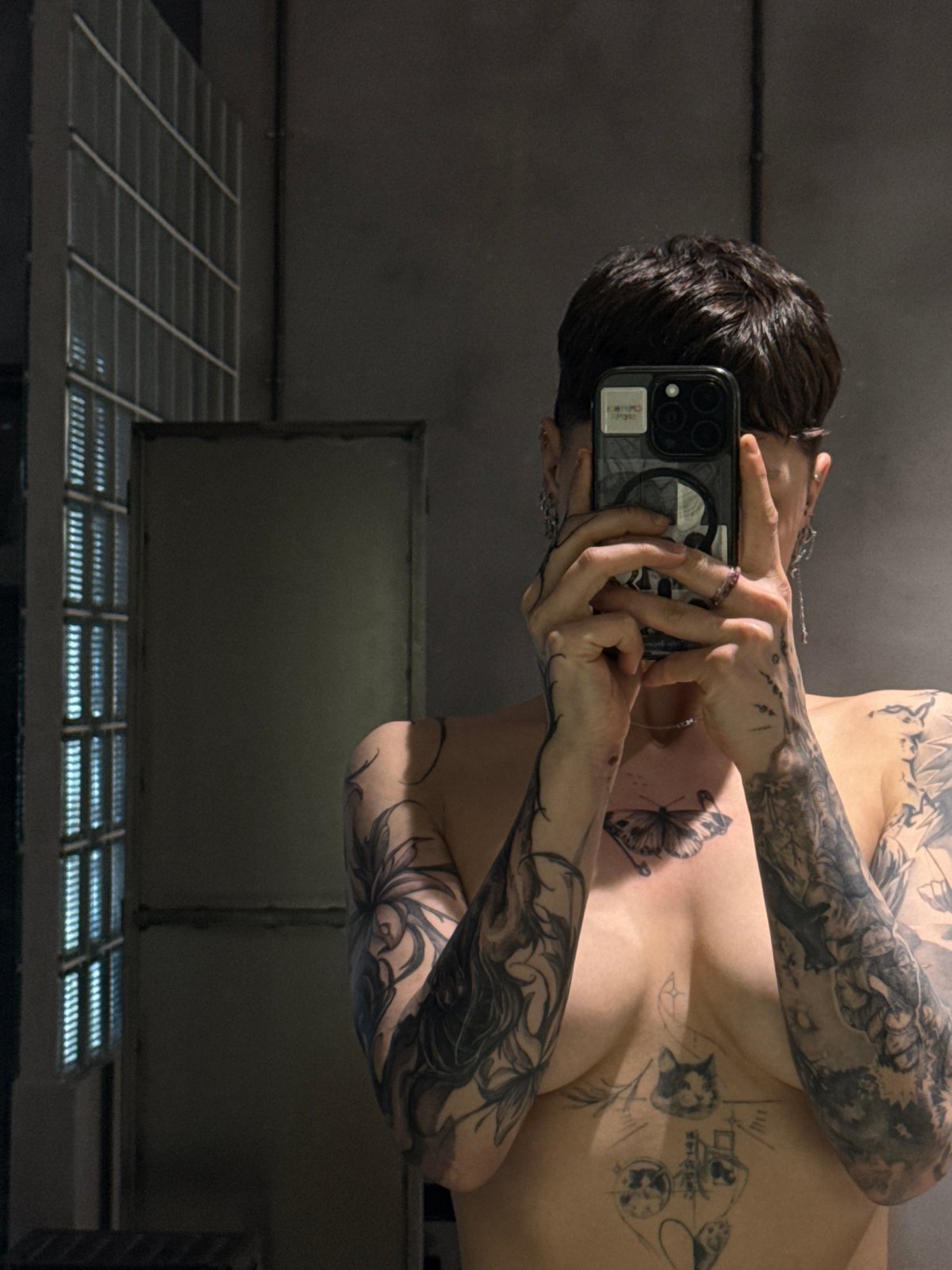Tattooed individual photographs mirror selfies in Moscow apartment