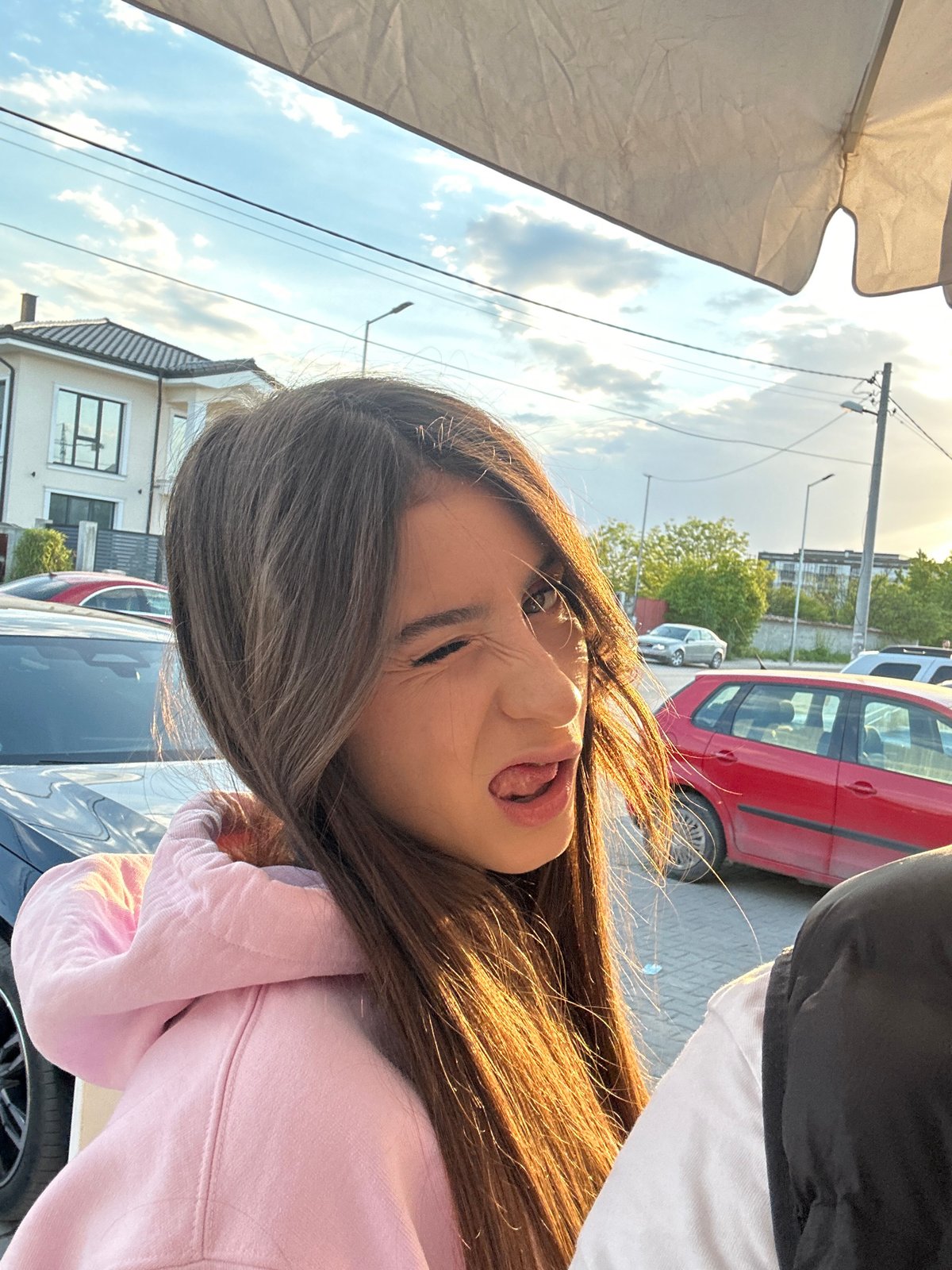 Woman takes playful selfies on Plovdiv street during golden hour