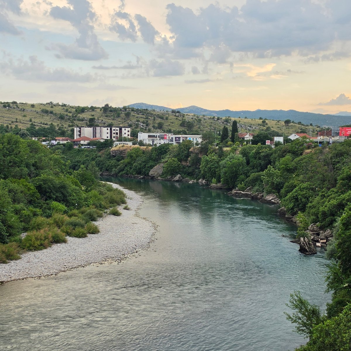Morača River flows peacefully through Podgorica amid green vegetation
