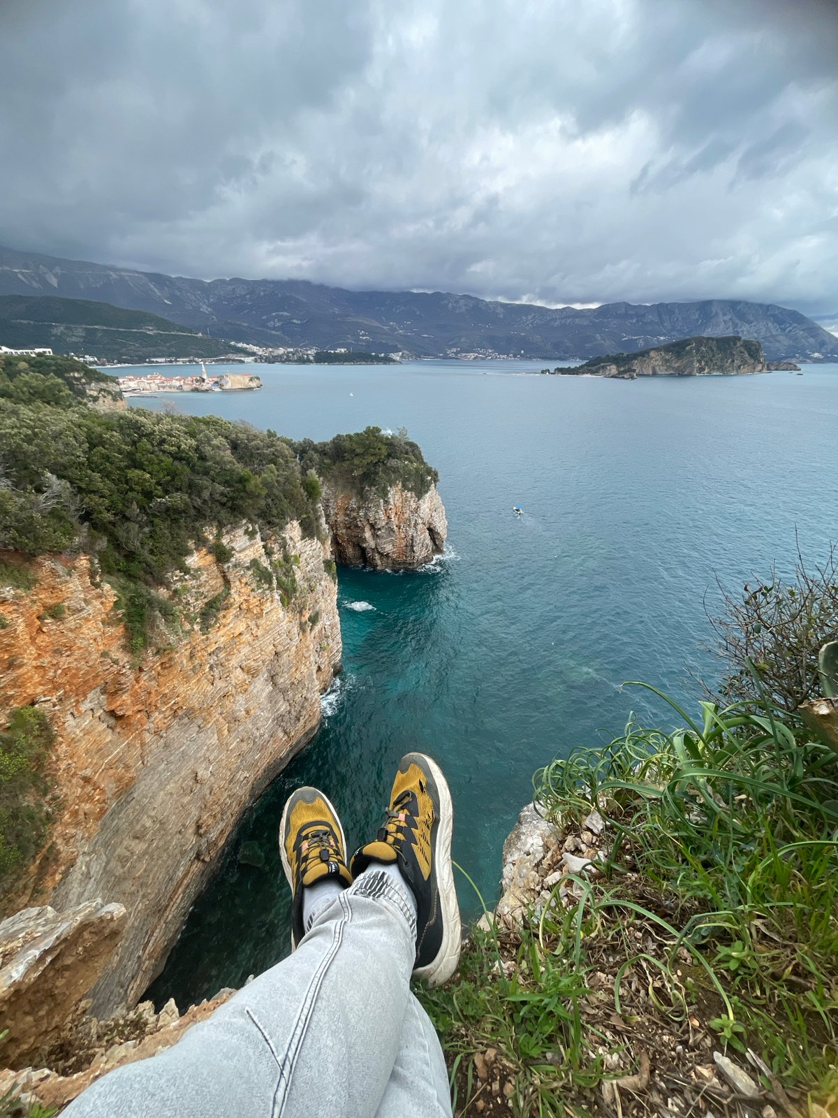 Tourist documents scenic clifftop views along Budva coastline