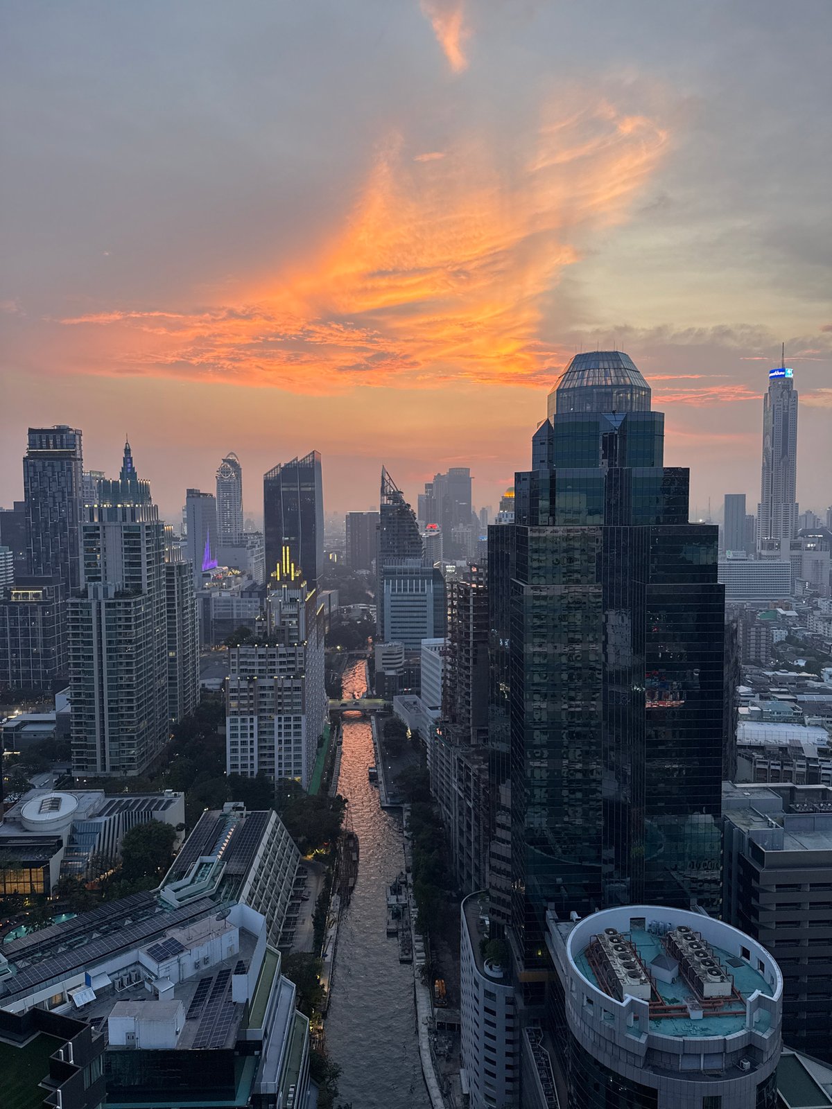 Bangkok sunset captured from elevated view showing skyline, canals