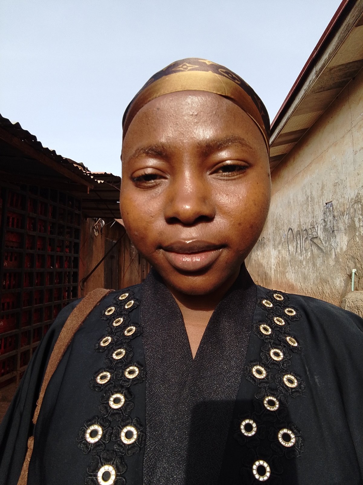 Woman in decorative head covering photographed smiling at camera