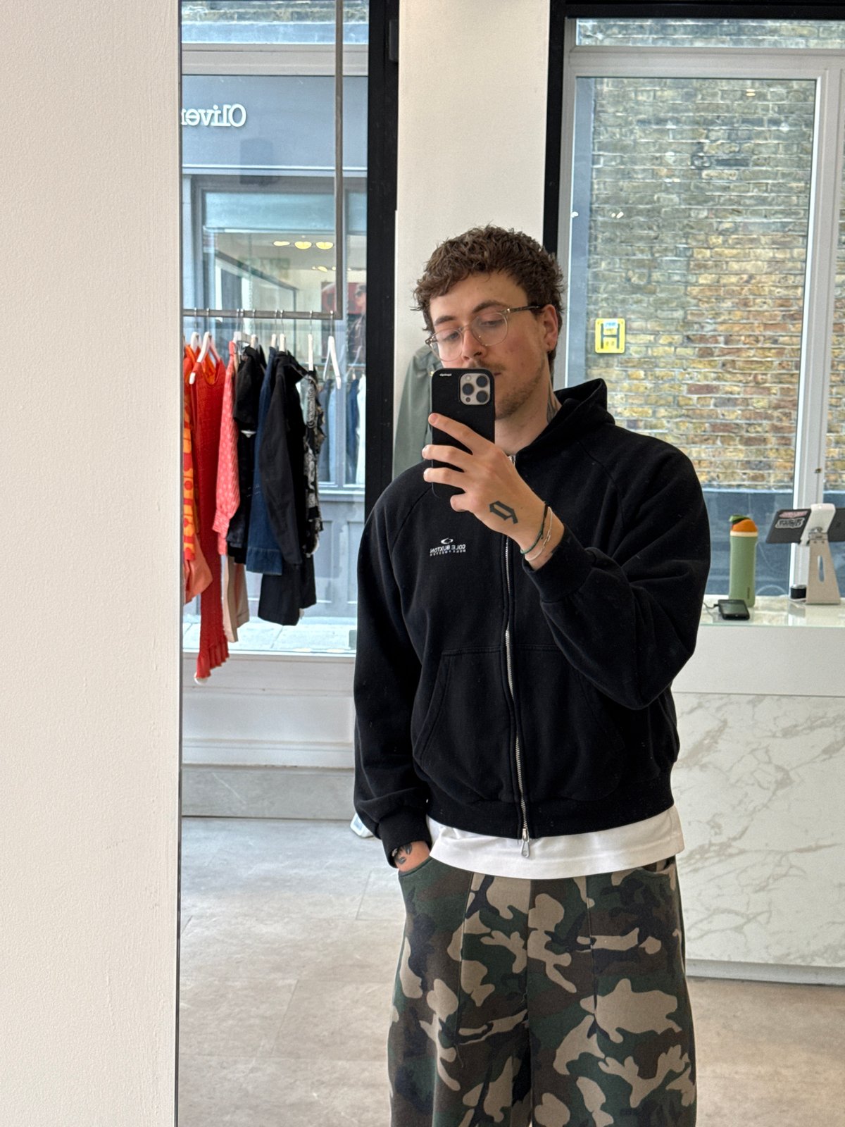 Customer takes mirror selfies at London vintage clothing store