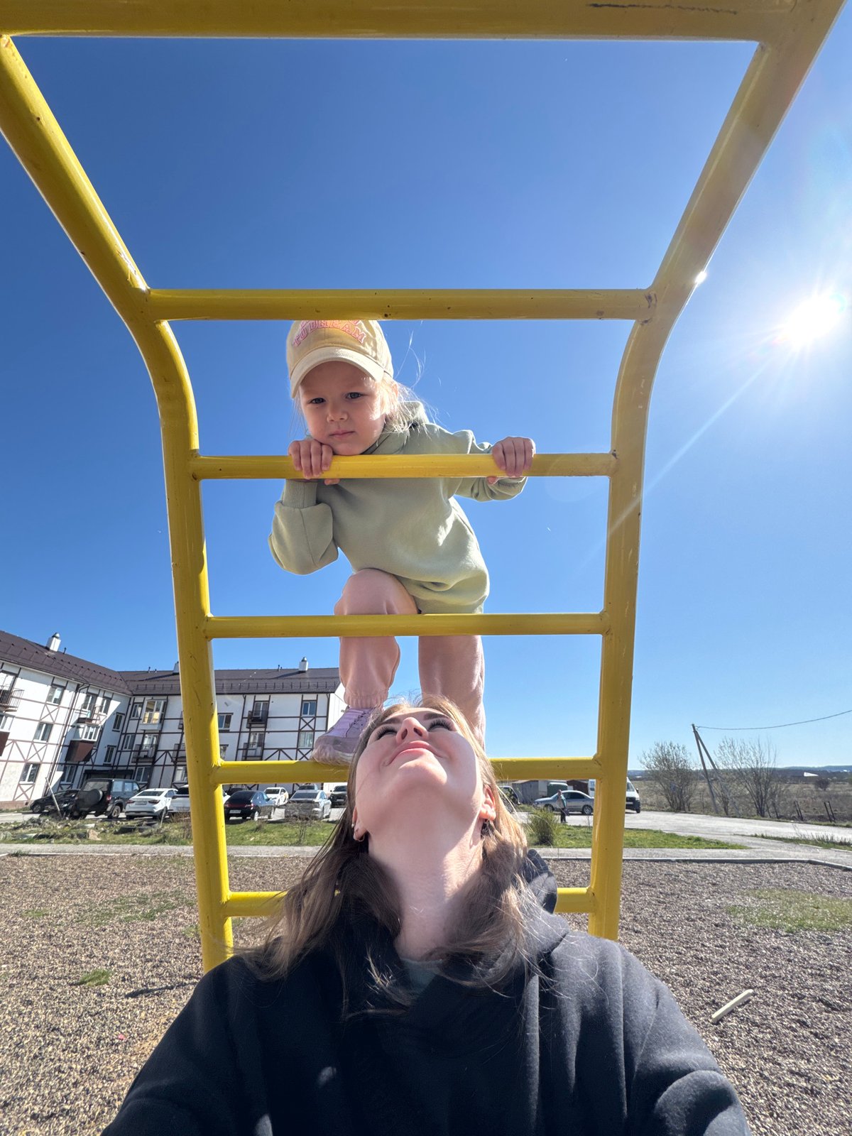 Child plays at playground in Горный, Russia while adult supervises