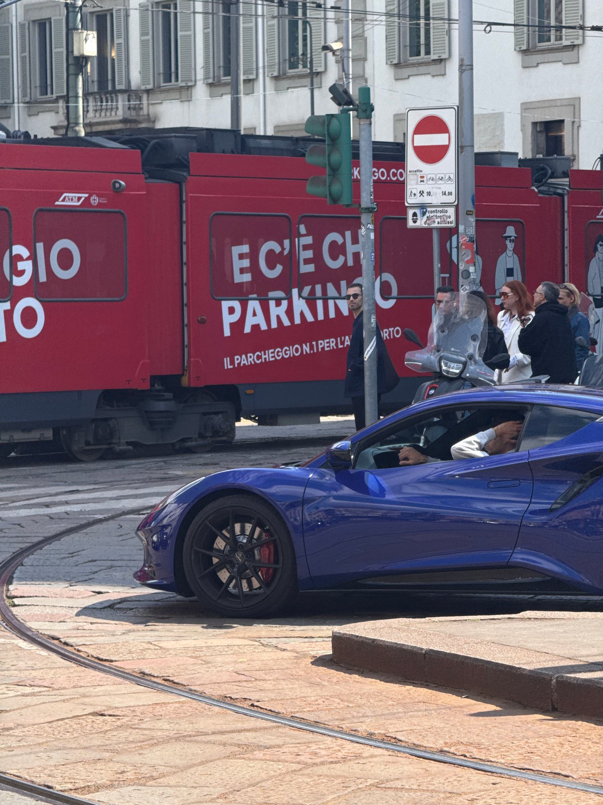 Milan street scene with parked vehicles and café accessories observed