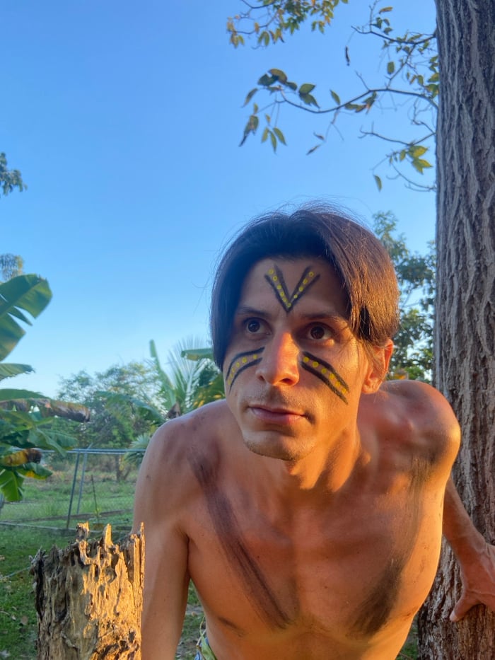 Man with ceremonial face paint documented in Venezuelan forest ritual