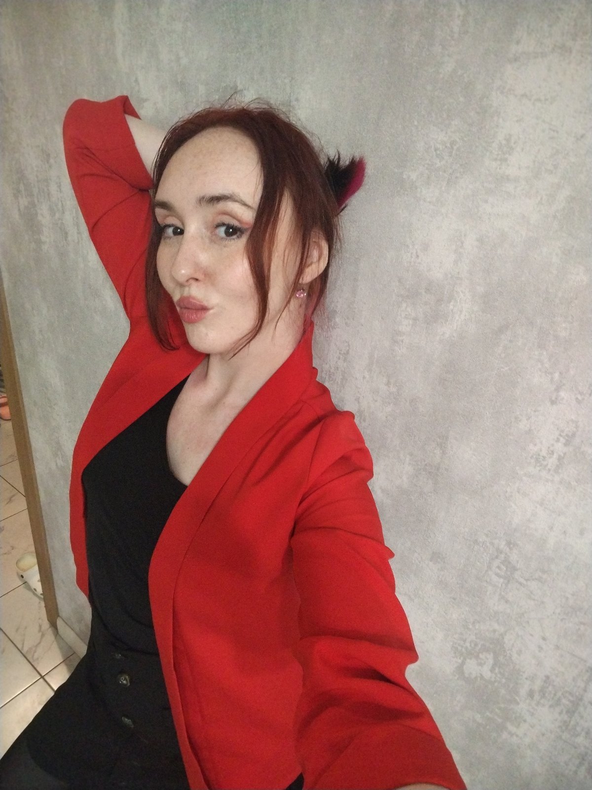 Woman poses in red blazer against wall in Izhevsk