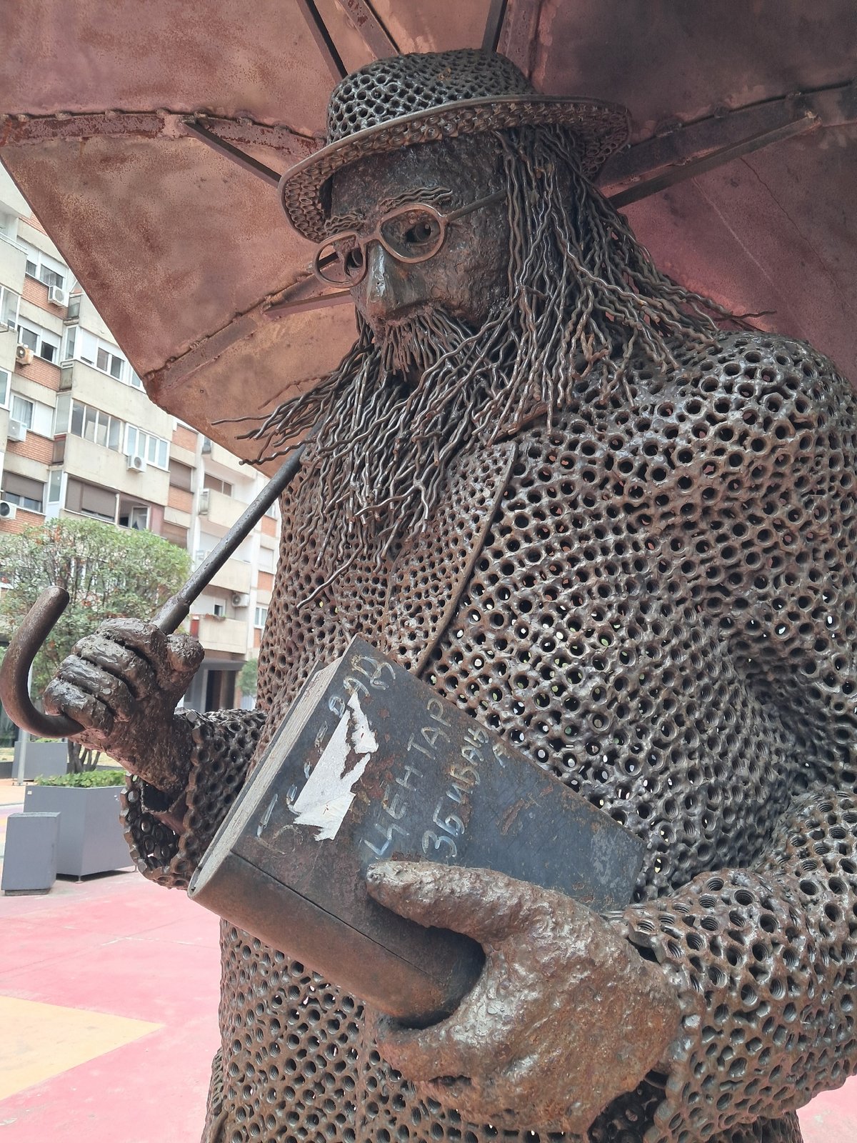 Belgrade chainmail sculpture of a figure with umbrella and book