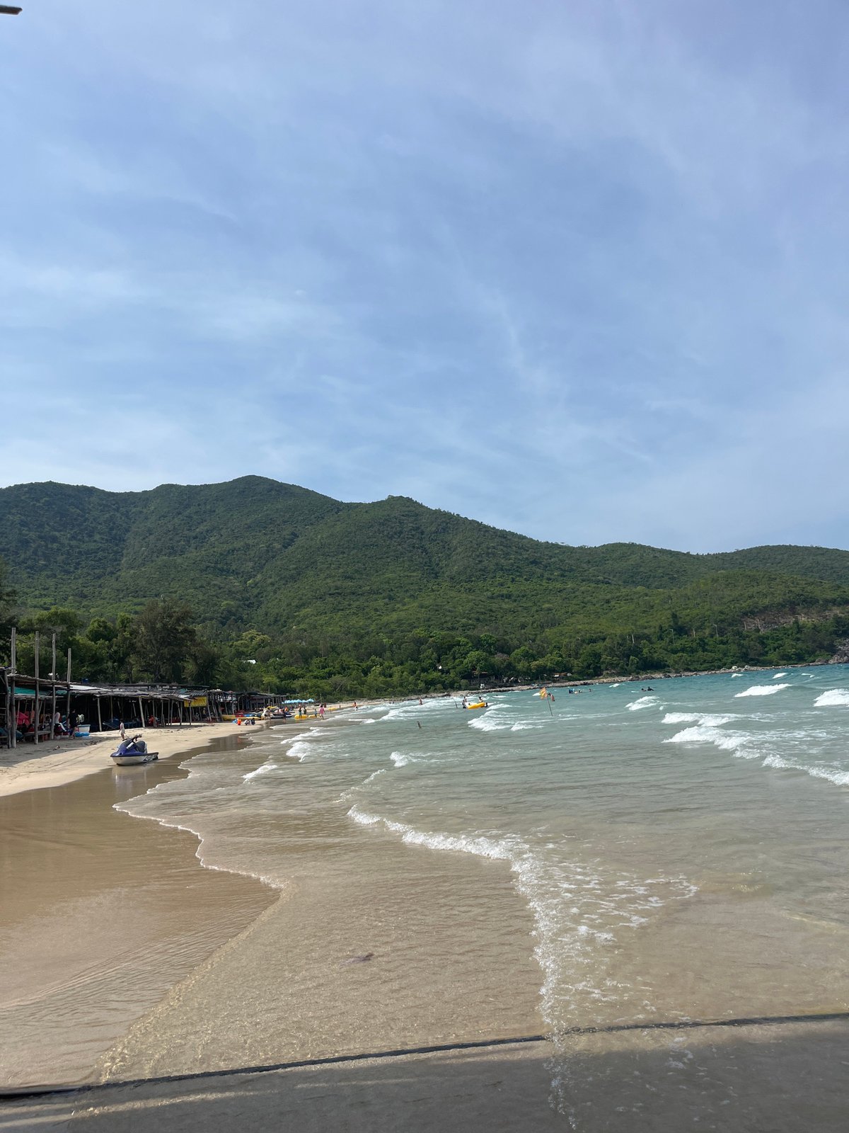 Beach morning on Cam Ranh Bay — vendors, kids, and waves