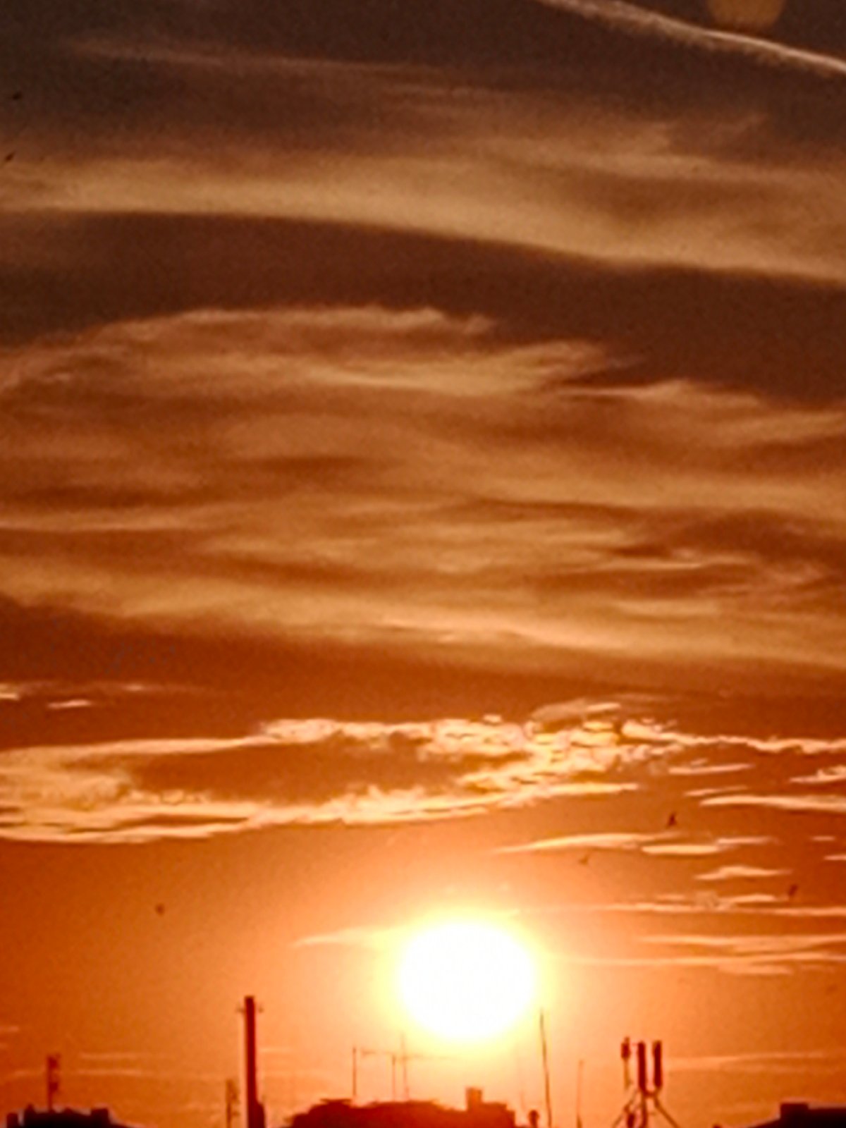 Bydgoszcz skyline silhouetted against a vivid summer sunset