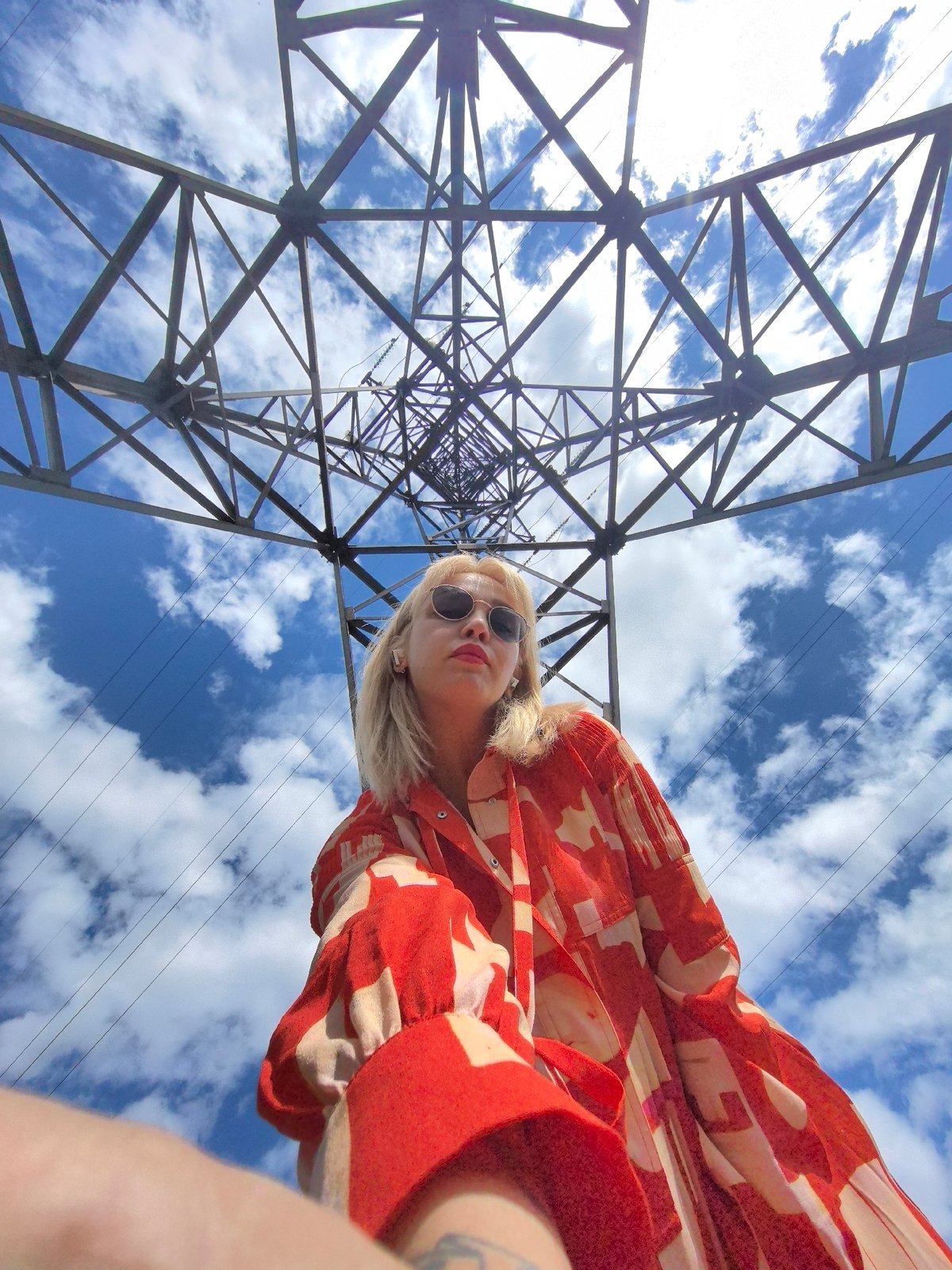 Woman poses near power towers in Noviy, Russia