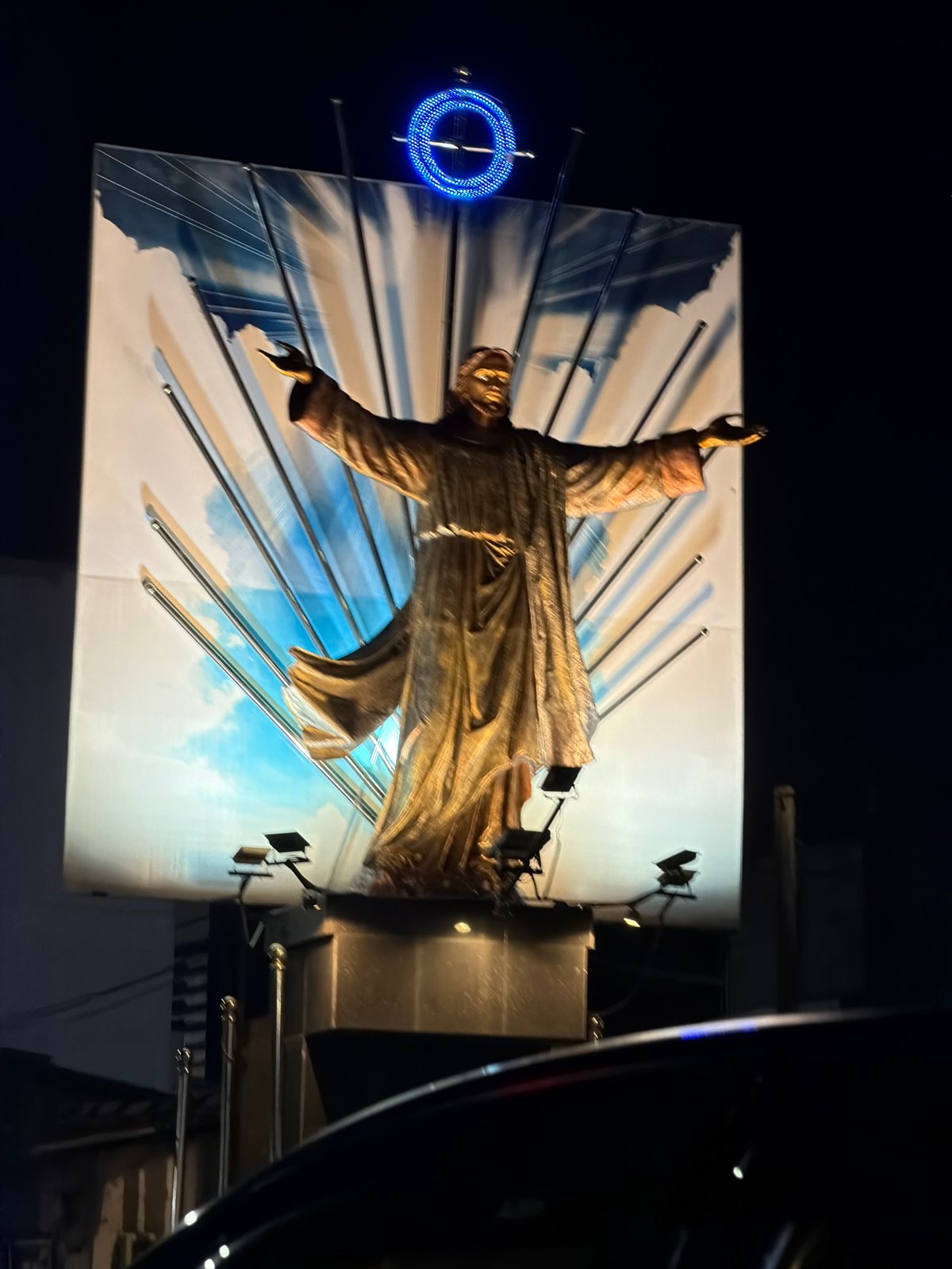 Illuminated Christ-like statue photographed at night in Ja-ela, Sri Lanka