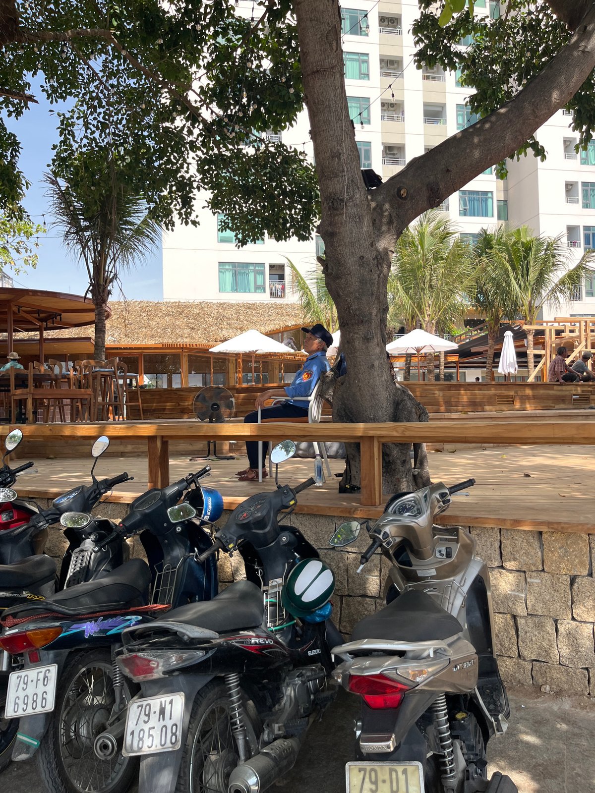 Motorbikes parked outside thatched-roof cafe in Nha Trang