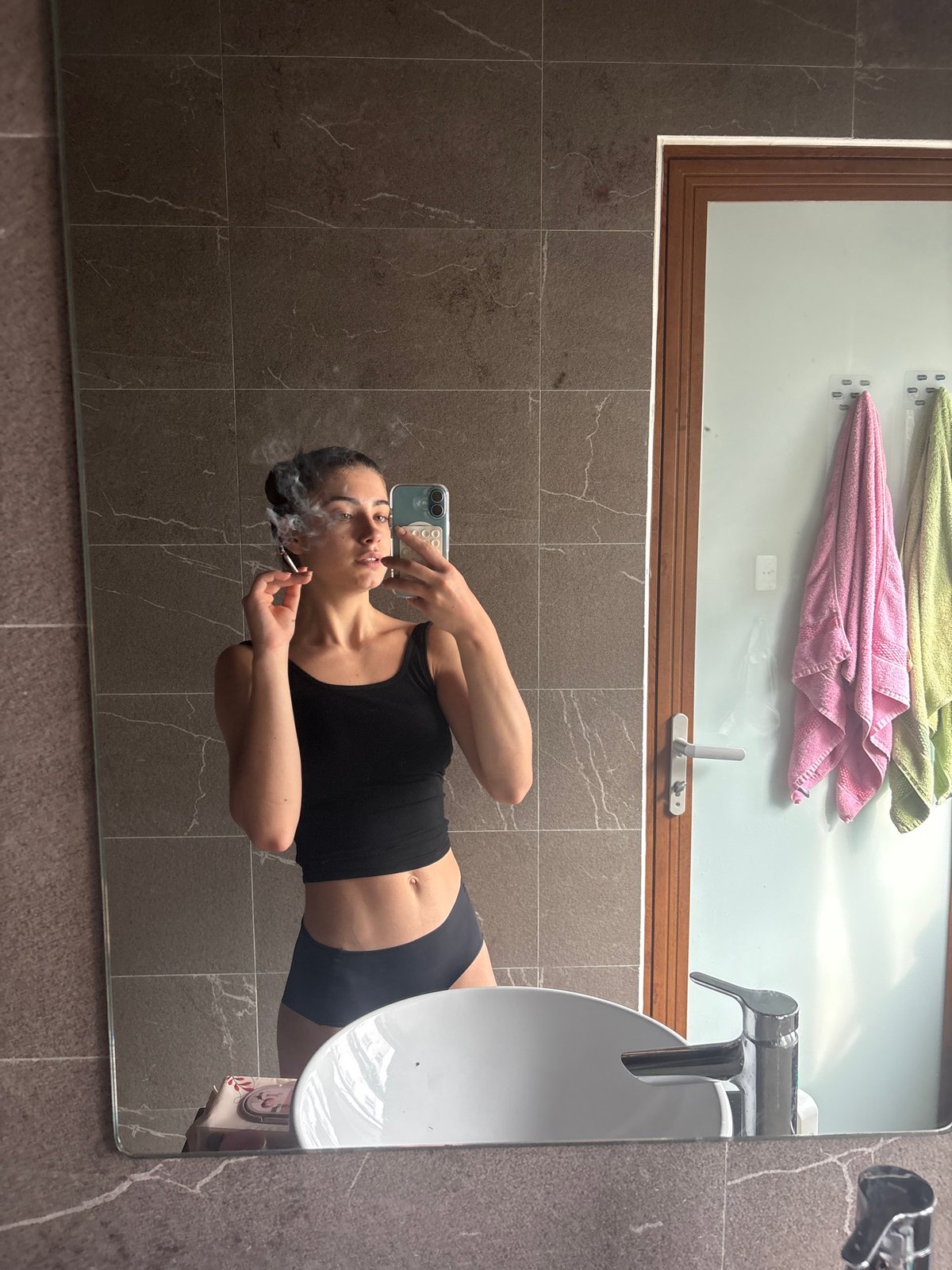 Woman takes mirror selfie in Đà Nẵng bathroom