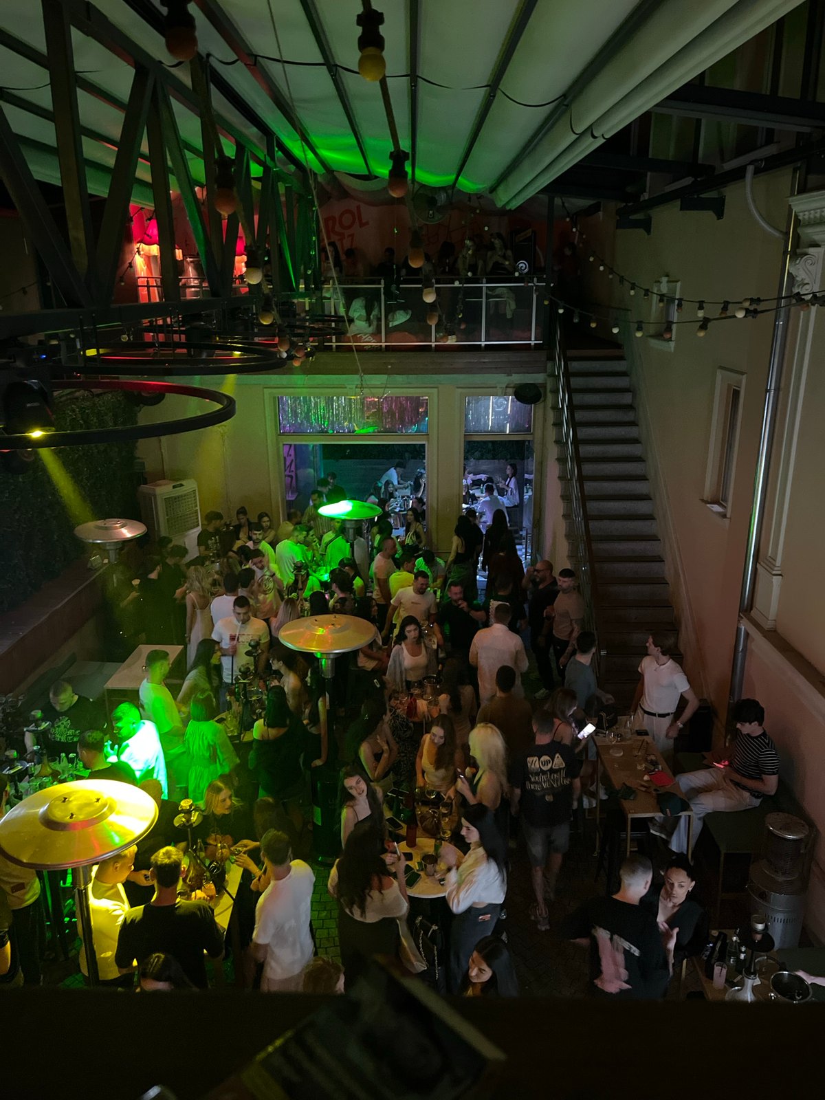 Crowded urban bar hosts lively evening social gathering