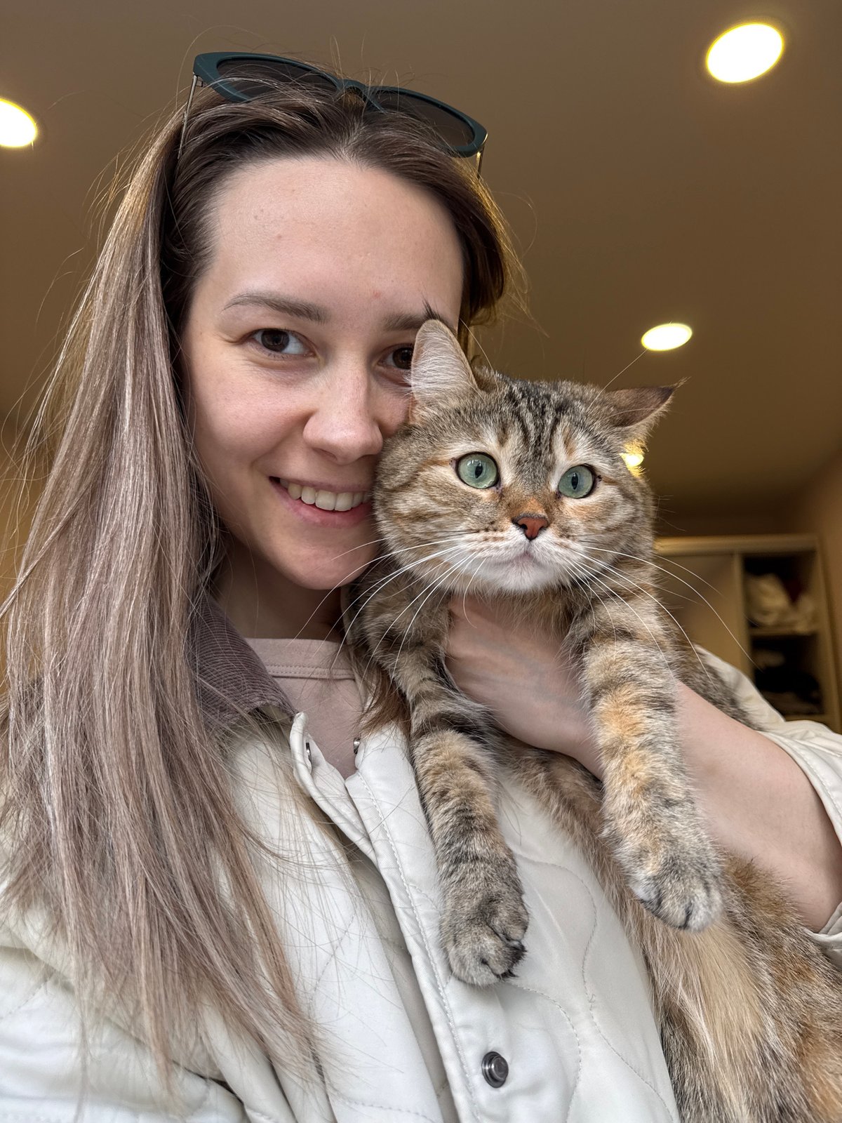 Woman poses with tabby cat in indoor portrait, Chaikovsky