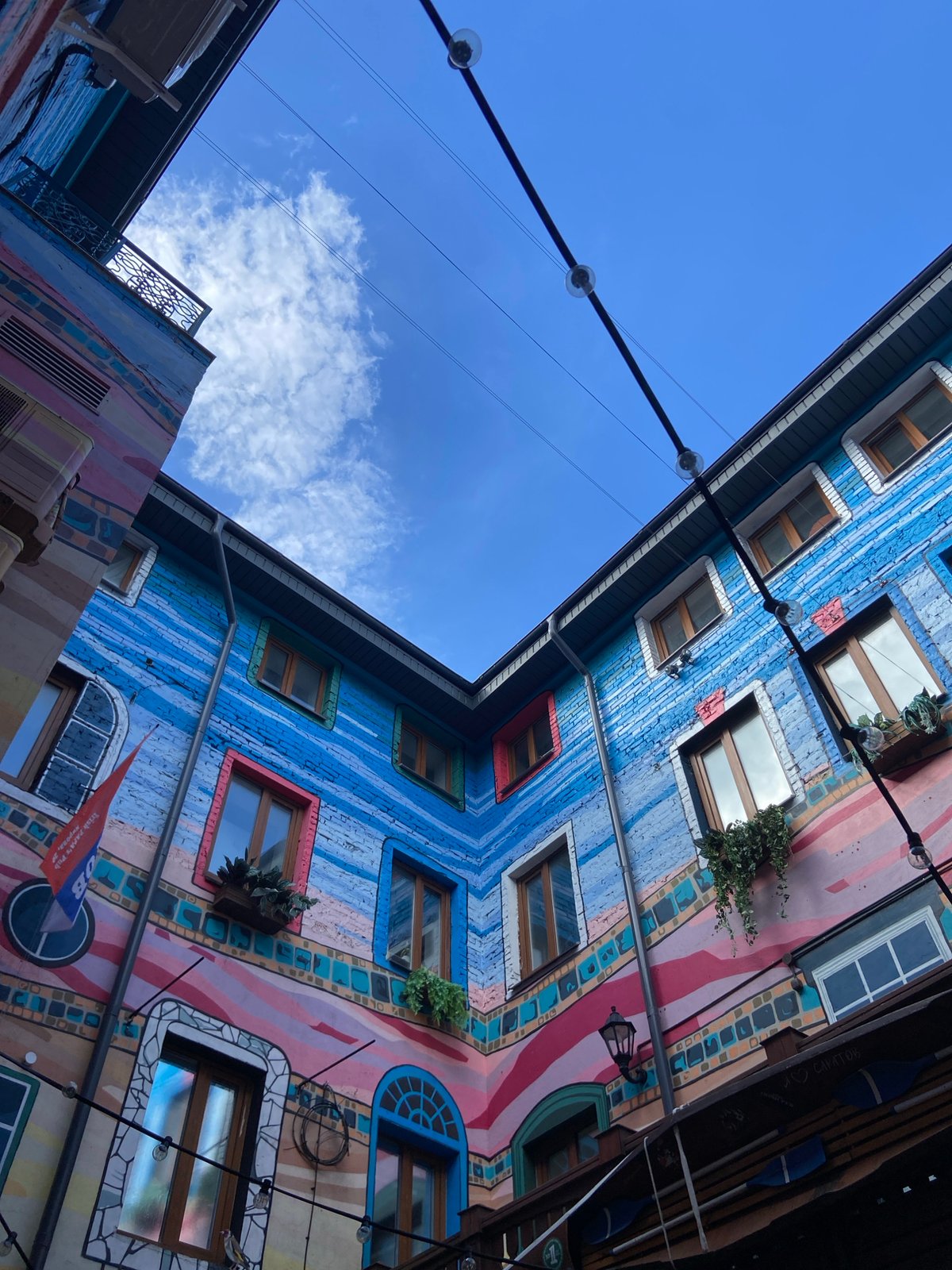 Red car towed on Saratov street amid colorful architecture