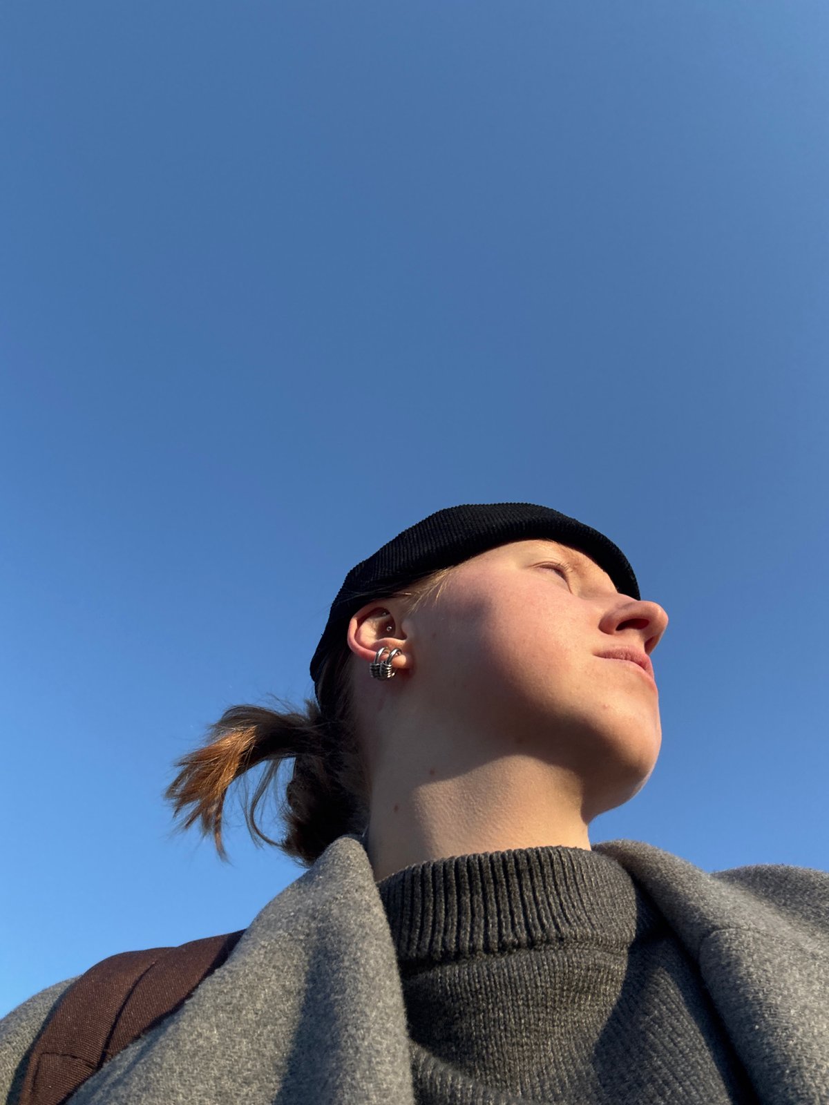 Person gazes upward at clear sky in Perm