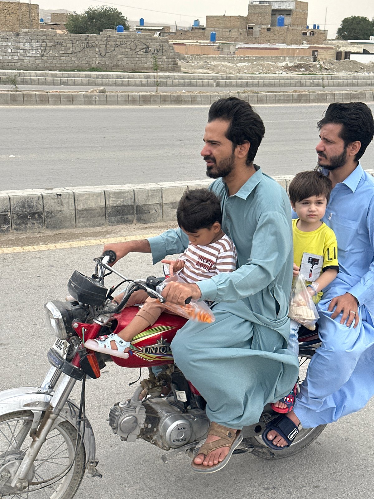 Family of three spotted sharing motorcycle ride in Quetta