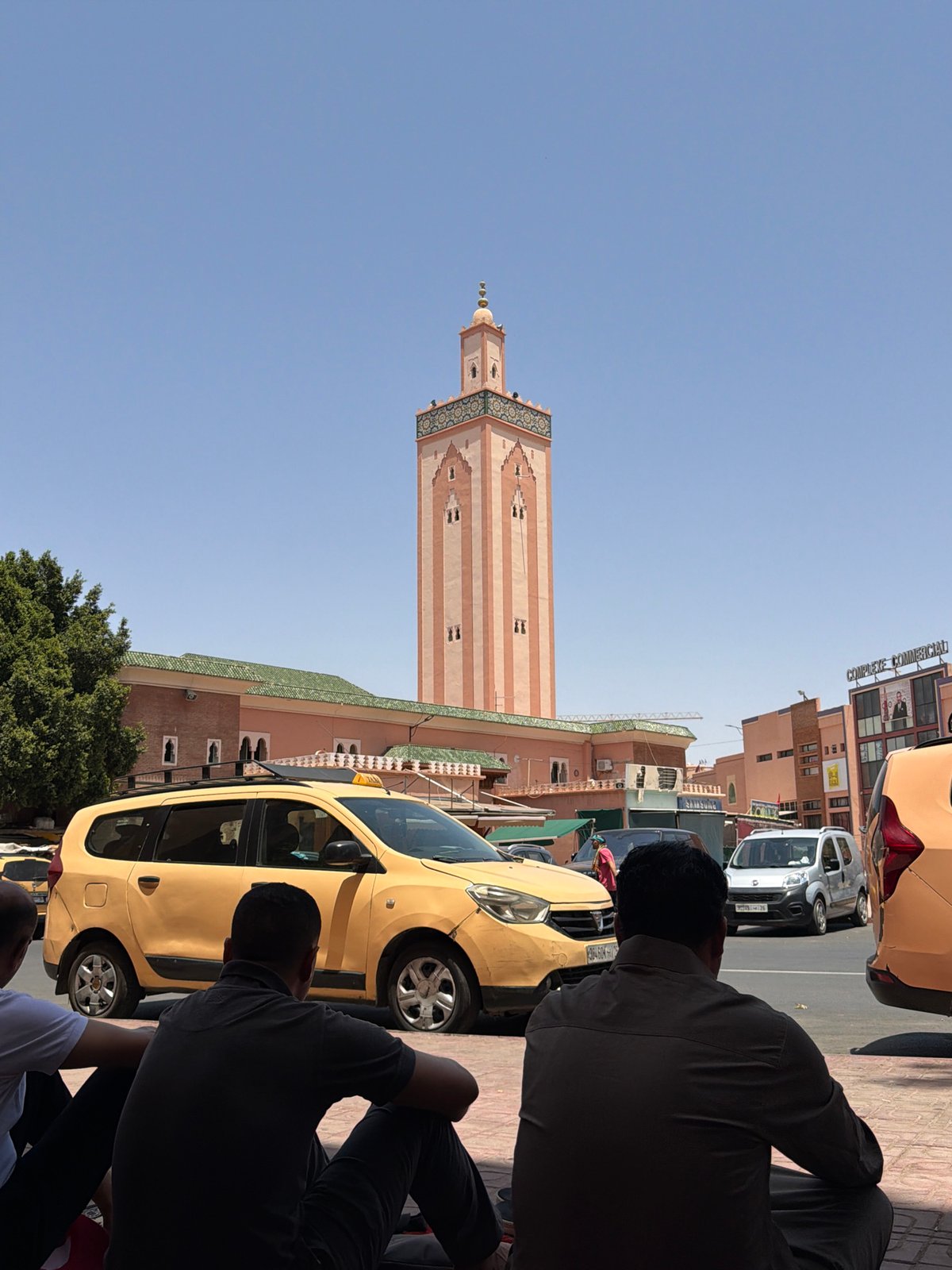 Tourist photographs iconic Koutoubia Mosque minaret in Marrakesh