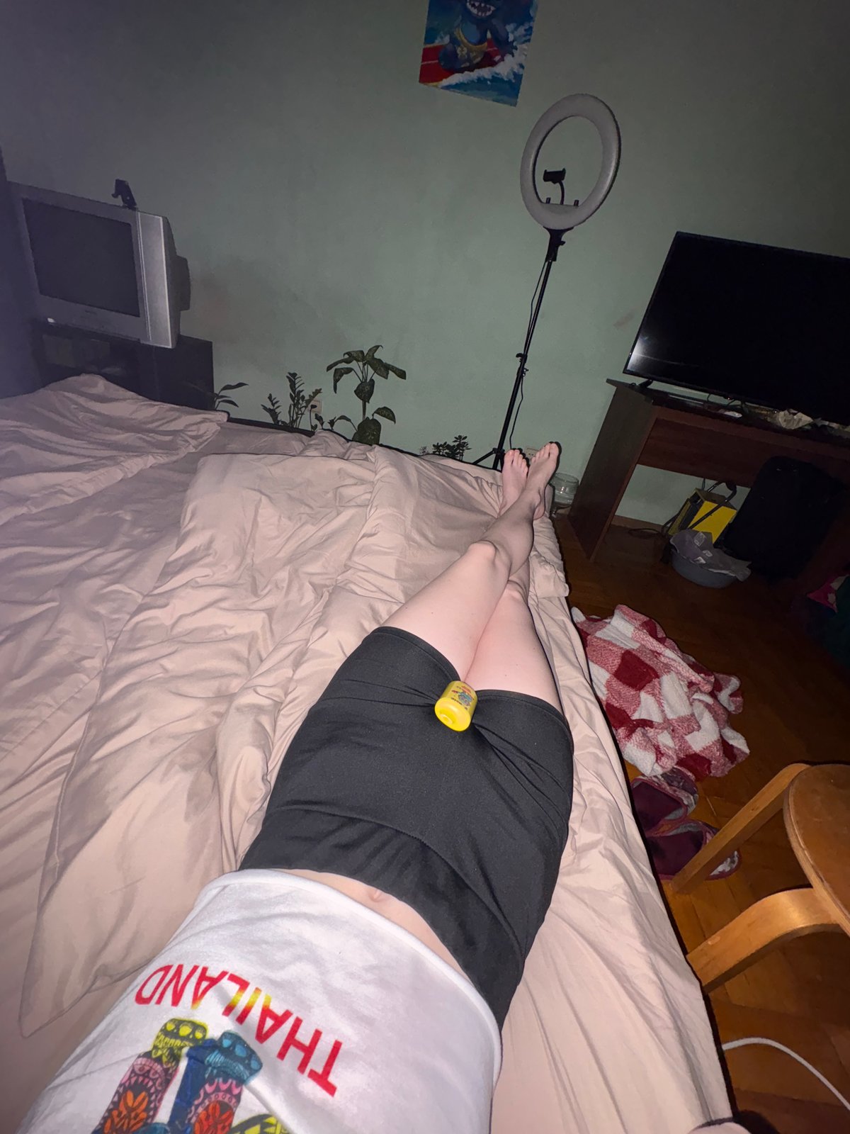 Person rests in bed wearing Thailand souvenir shirt