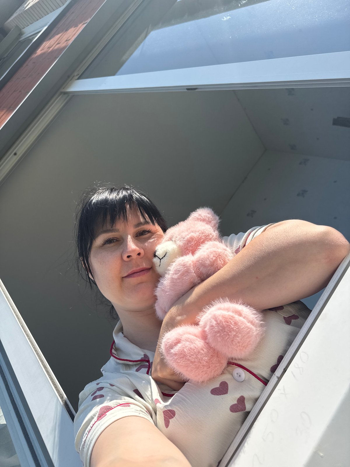 Woman with pink teddy bear spotted at window in Zav'yalovo