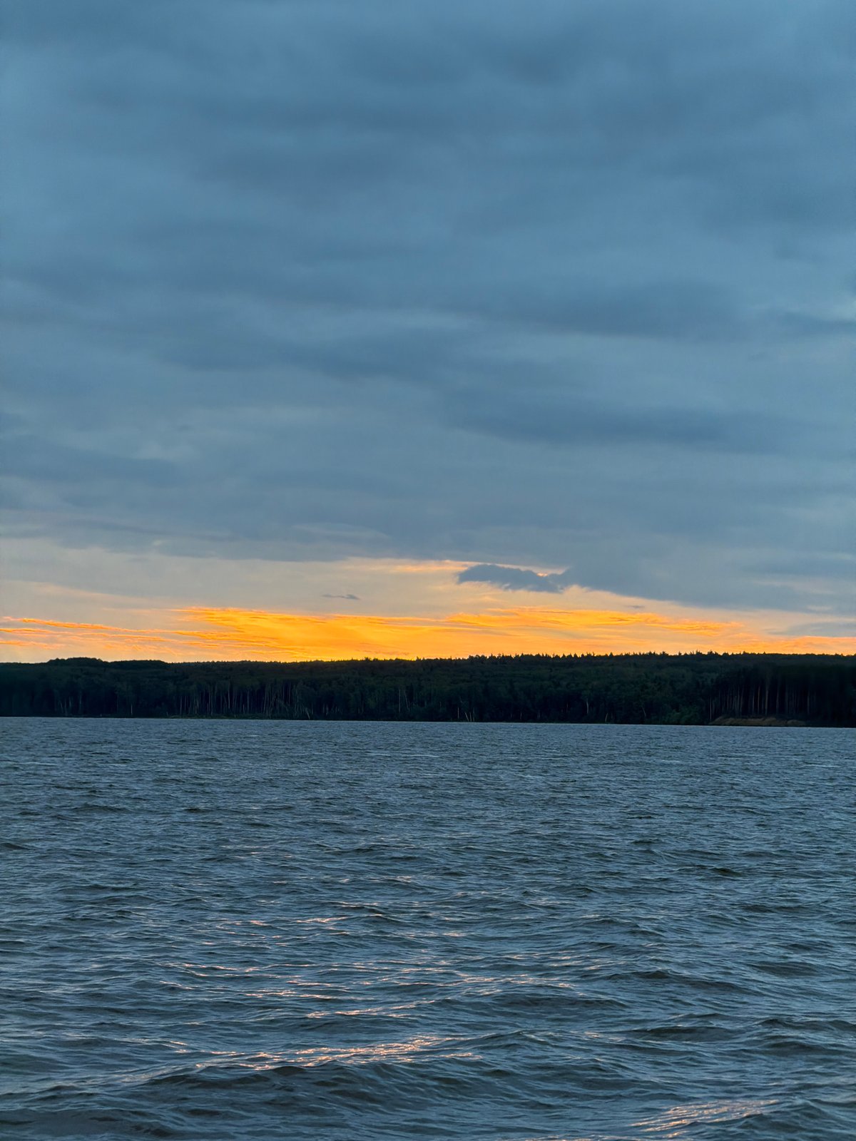 Man photographed during twilight fishing scene in Chaikovsky, Russia