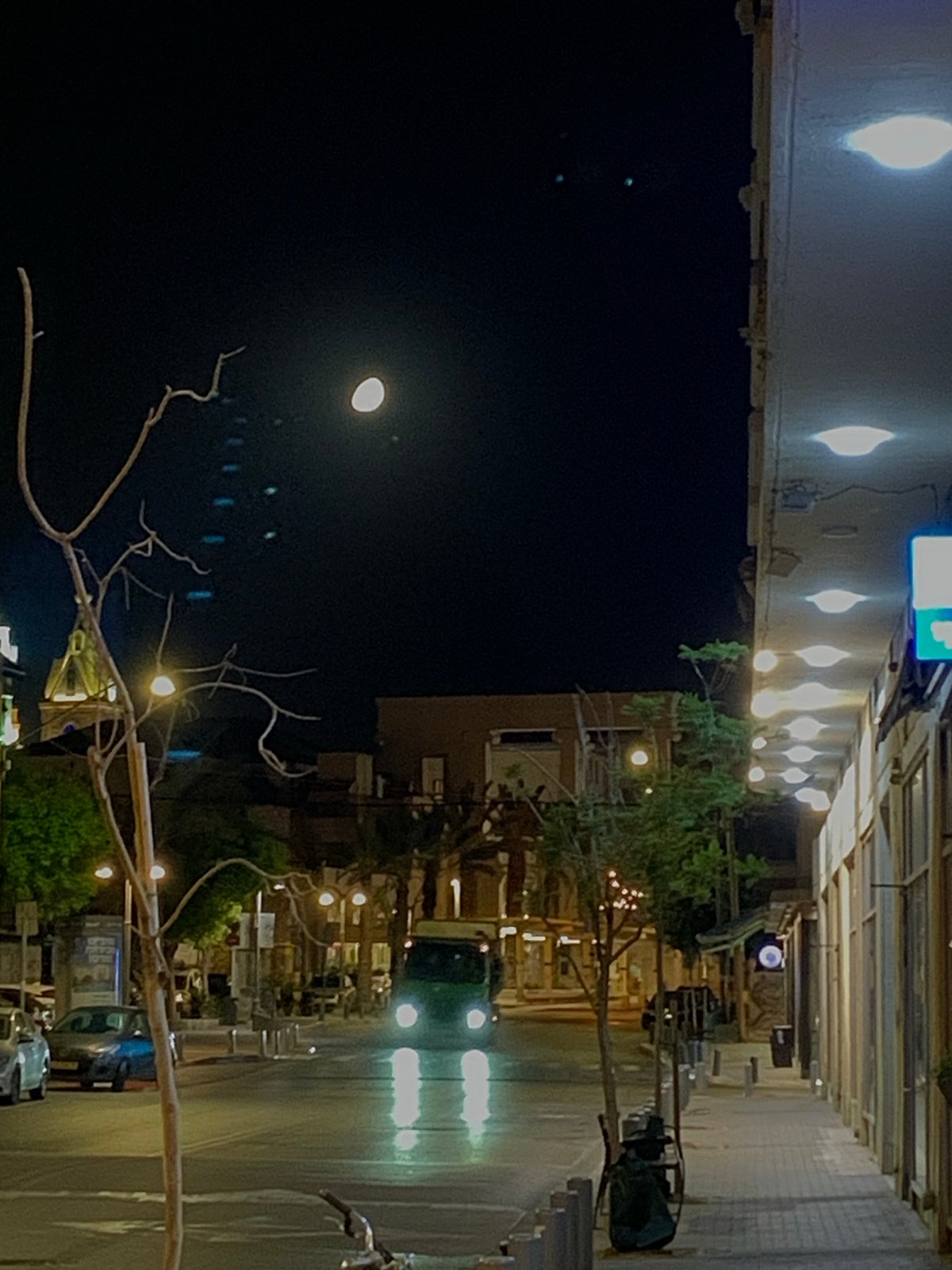 Nighttime street scene captured in Tel-Aviv with full moon