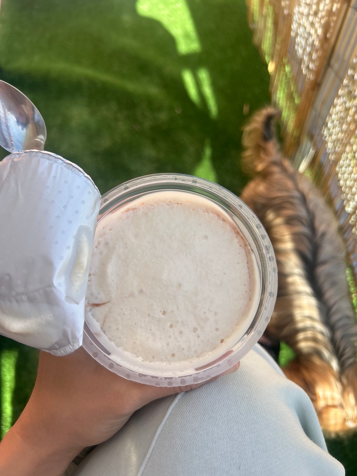 Person eats yogurt from plastic container in Burgas