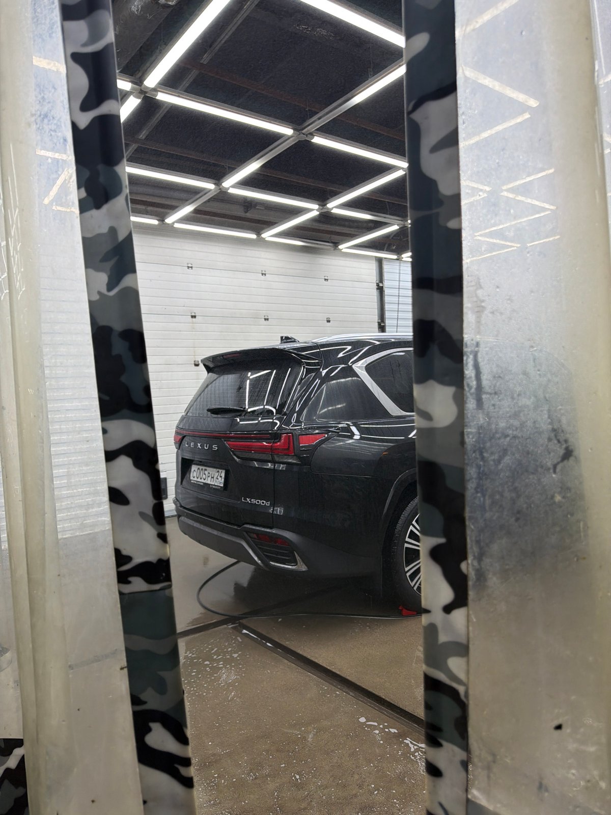 Auto repair shop workers service luxury vehicles in Krasnoyarsk