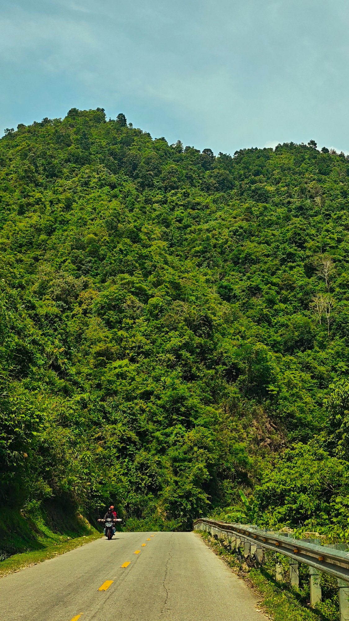 Morning traffic flows through scenic mountain road in Vietnam