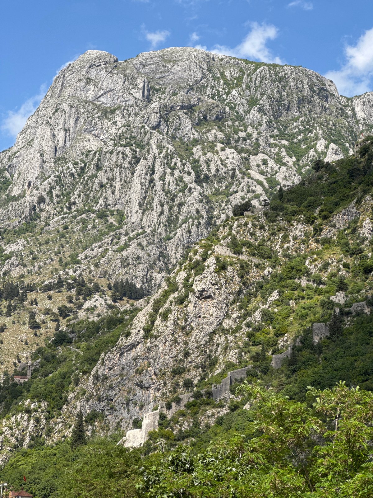 Rocky mountainside with winding pathway observed in Škaljari, Montenegro